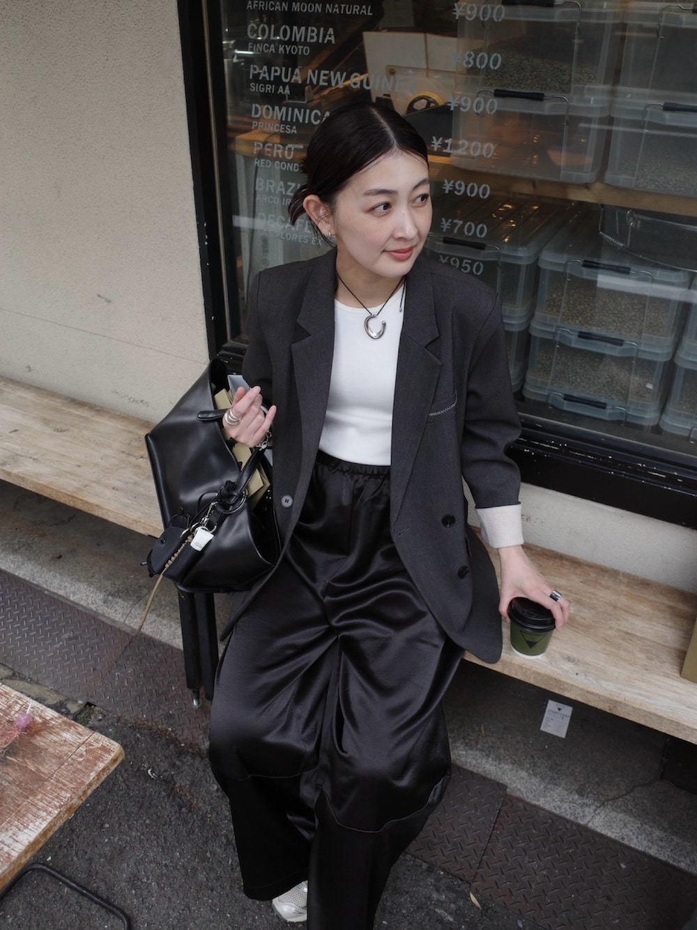 ブラック系のその他パンツ、グレー系のテーラードジャケット、ベージュ系のその他小物を着用したレディースの春コーディネートの4枚目の写真