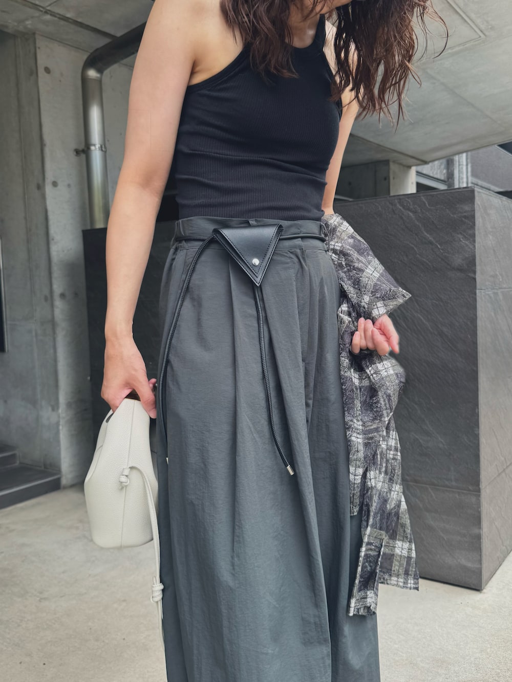 ブラック系のシャツ/ブラウス、グレー系のスラックス、ブラック系のサンダルを着用したレディースの夏コーディネートの3枚目の写真
