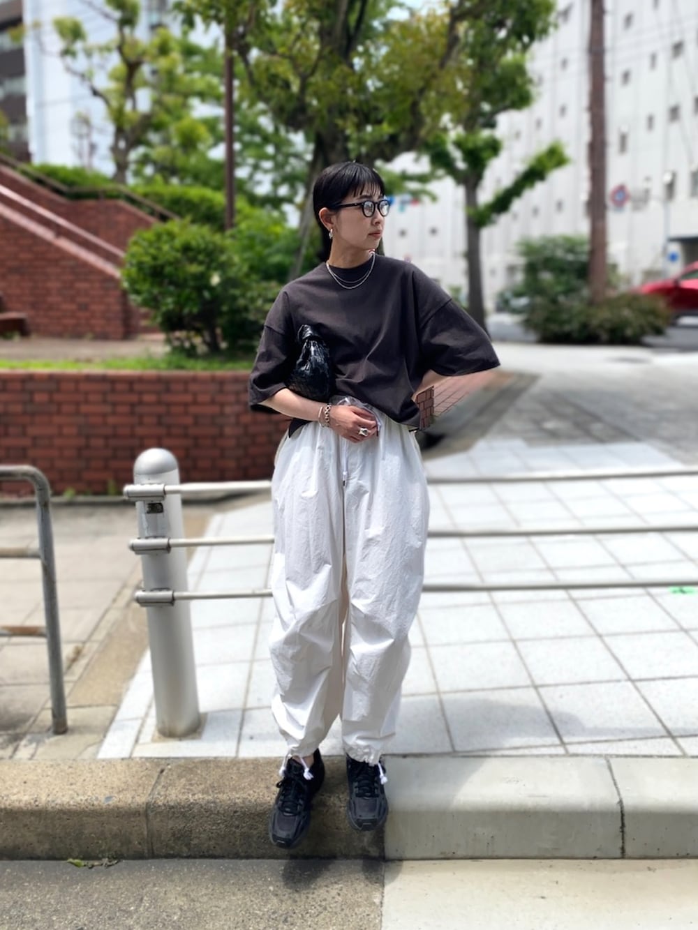 ブラック系のTシャツ/カットソー、ホワイト系のその他パンツ、ブラック系のスニーカーを着用したレディースの夏コーディネートの3枚目の写真