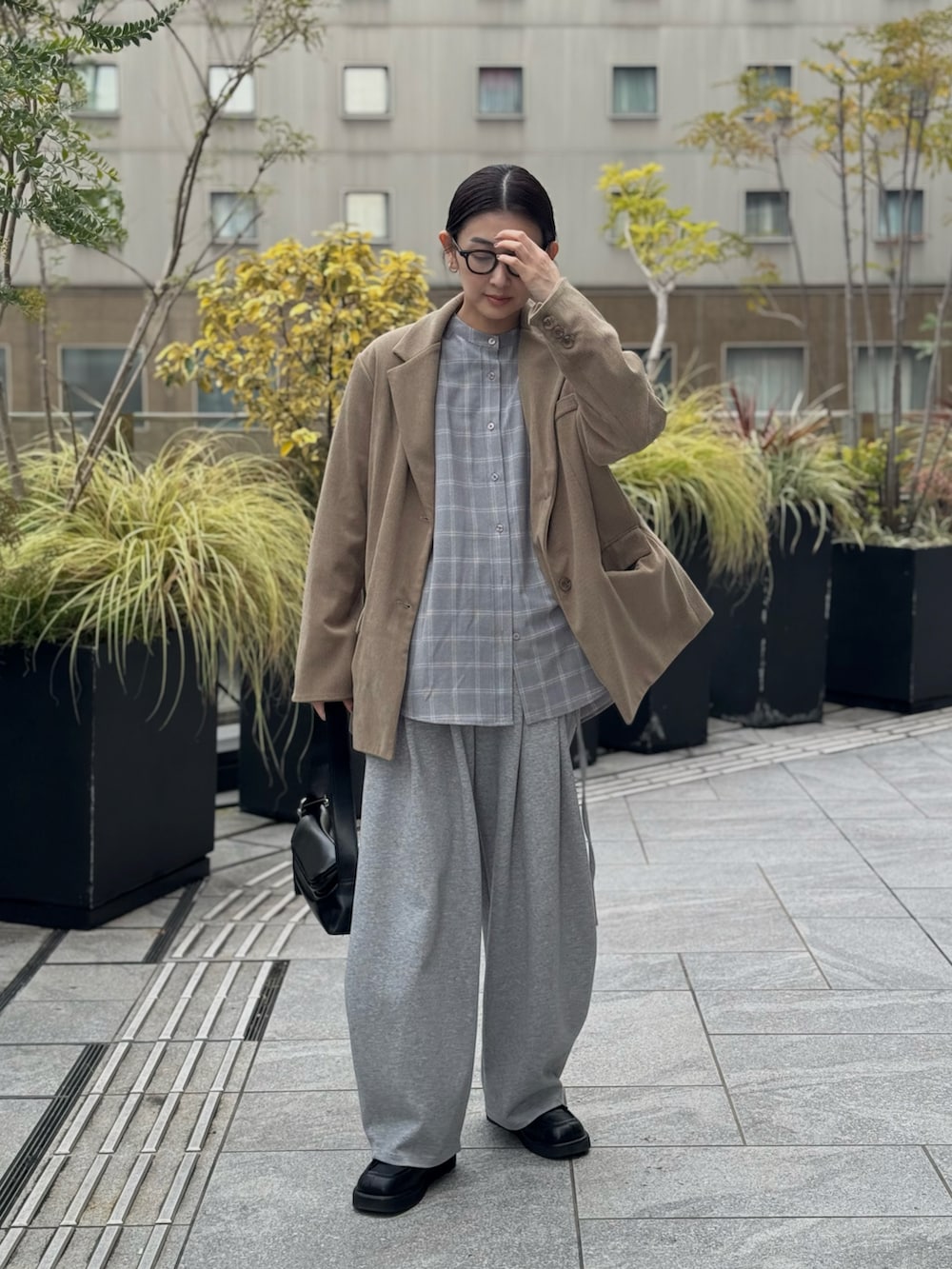 グレー系のシャツ/ブラウス、グレー系のスウェットパンツ、ブラック系のローファーを着用したレディースの春コーディネートの4枚目の写真