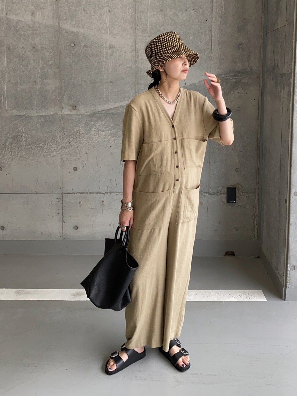 グリーン系のサロペット/オーバーオール、ブラック系のトートバッグ、ブラック系のサンダルを着用したレディースの夏コーディネートの2枚目の写真