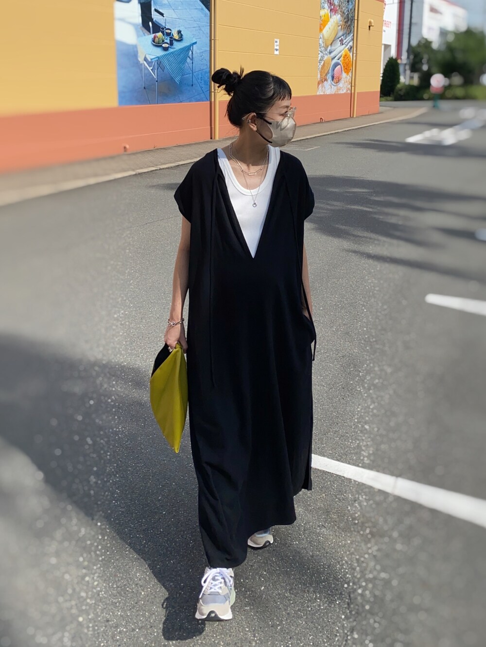 ブラック系のワンピース、ホワイト系のタンクトップ、イエロー系のハンドバッグを着用したレディースの秋コーディネートの2枚目の写真