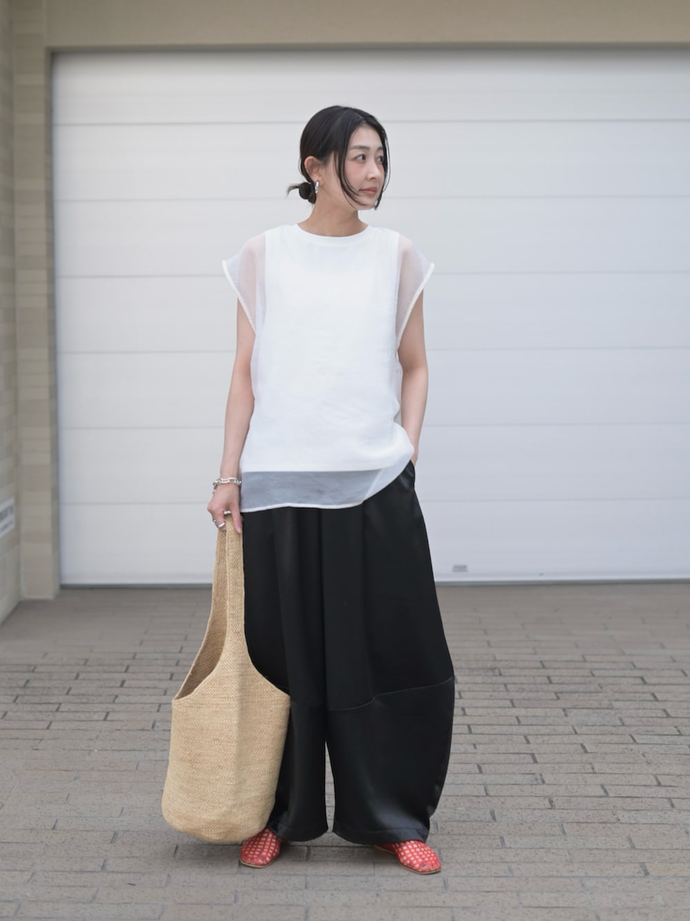 ブラック系のその他パンツ、ホワイト系のTシャツ/カットソー、ベージュ系のかごバッグを着用したレディースの夏コーディネートの5枚目の写真
