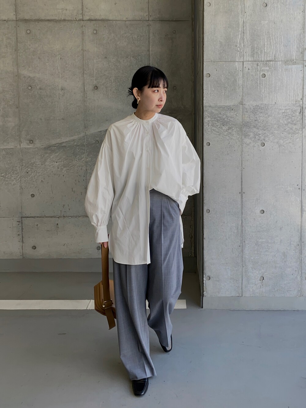 ホワイト系のシャツ/ブラウス、グレー系のスラックス、ブラウン系のショルダーバッグを着用したレディースの春コーディネートの2枚目の写真