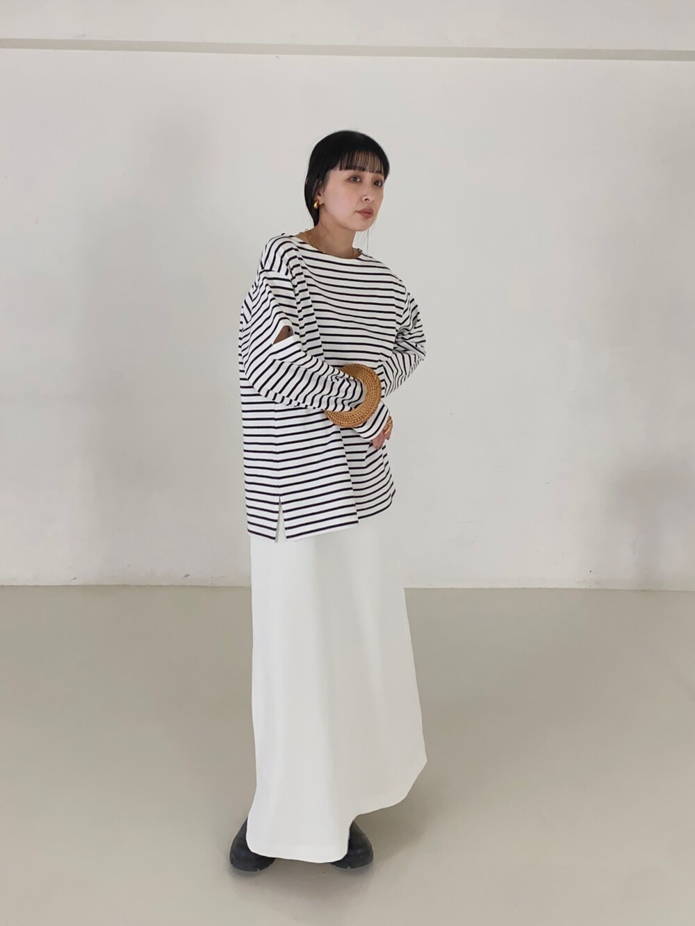 ブラック系のTシャツ/カットソー、ホワイト系のスカートを着用したレディースの春コーディネートの2枚目の写真