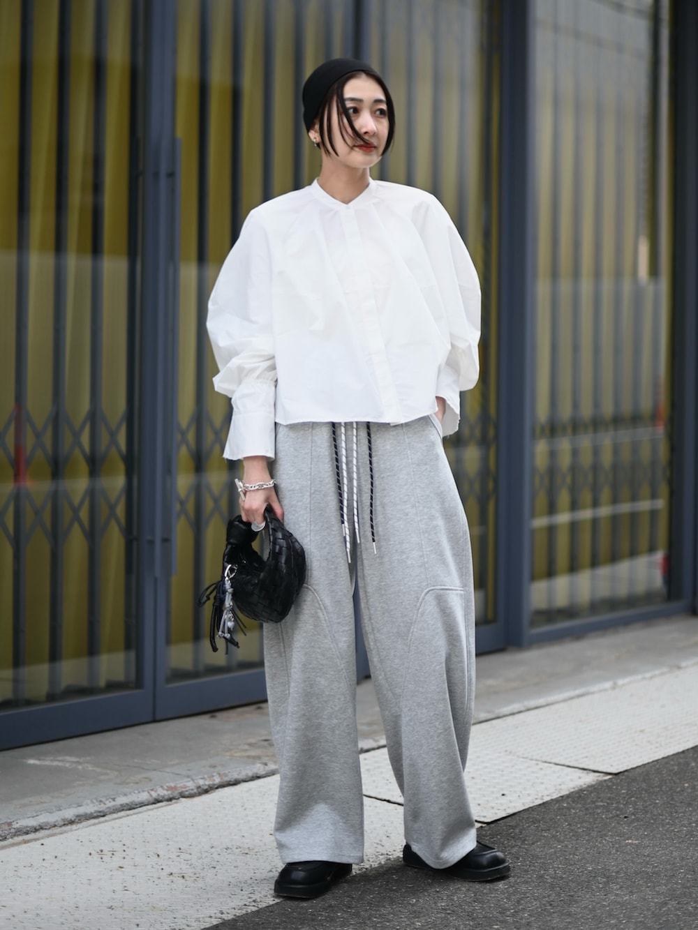 ホワイト系のシャツ/ブラウス、グレー系のスウェットパンツ、ブラック系のローファーを着用したレディースの春コーディネートの5枚目の写真