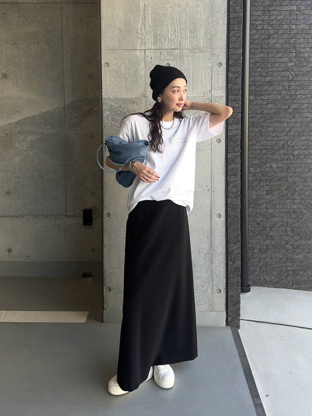 シルバー系のTシャツ/カットソー、ホワイト系のスニーカー、ブラック系のスカートを着用したレディースの秋コーディネートの3枚目の写真