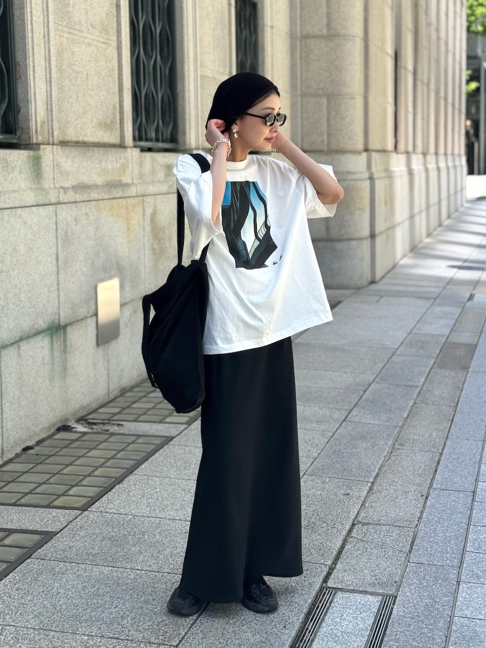 ホワイト系のTシャツ/カットソー、ブラック系のスカート、ブラック系のトートバッグを着用したレディースの春コーディネートの2枚目の写真