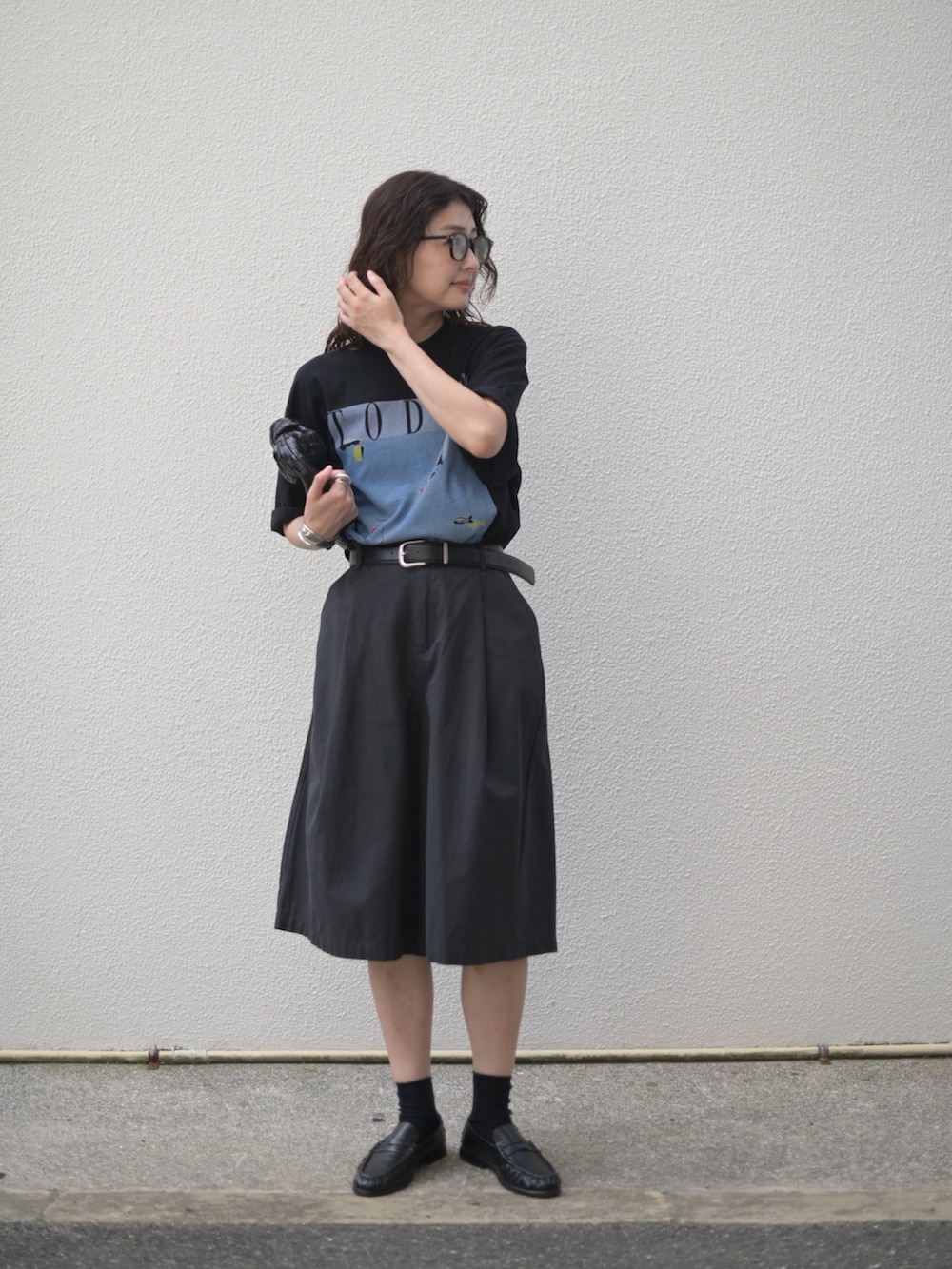 ブラック系のTシャツ/カットソー、ブラック系のその他パンツ、ブラック系のローファーを着用したレディースの秋コーディネートの4枚目の写真