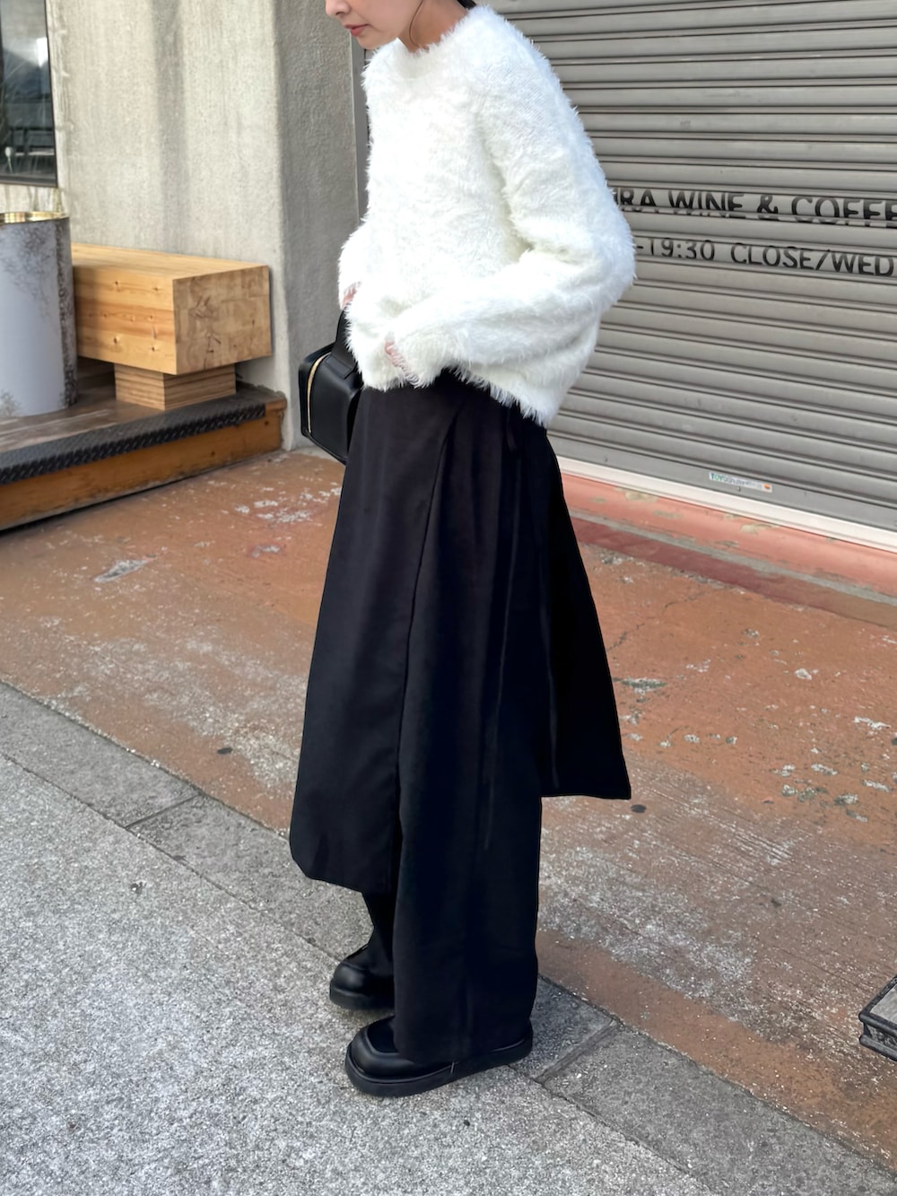 ホワイト系のニット/セーター、ブラック系のスラックス、ブラック系のローファーを着用したレディースの冬コーディネートの2枚目の写真