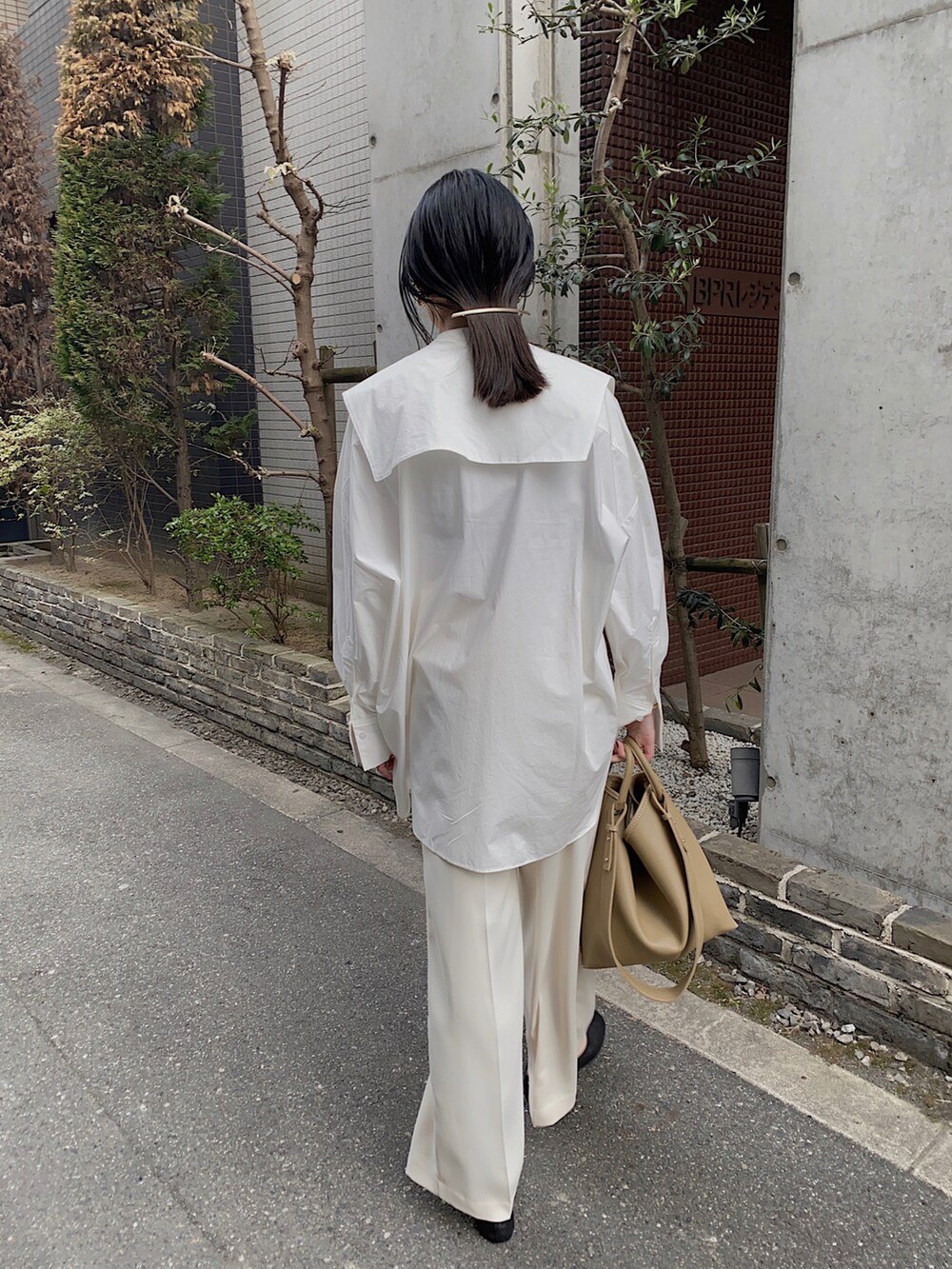 ホワイト系のシャツ/ブラウス、ベージュ系のハンドバッグ、ブラック系のバレエシューズを着用したレディースの冬コーディネートの2枚目の写真