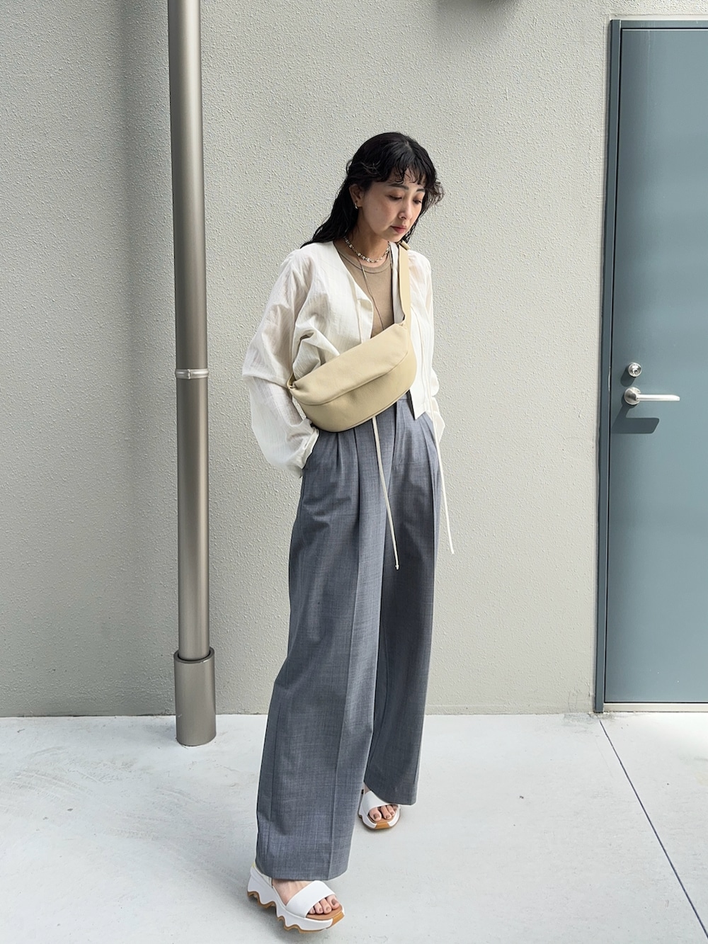 ホワイト系のシャツ/ブラウス、ベージュ系のショルダーバッグ、グレー系のスラックスを着用したレディースの春コーディネートの4枚目の写真