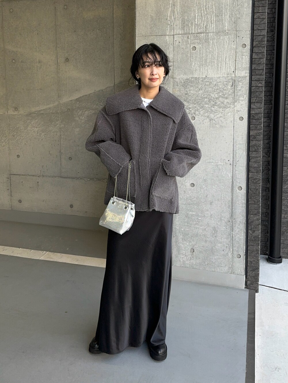 グレー系のその他アウター、シルバー系のショルダーバッグ、ブラック系のスカートを着用したレディースの冬コーディネートの5枚目の写真