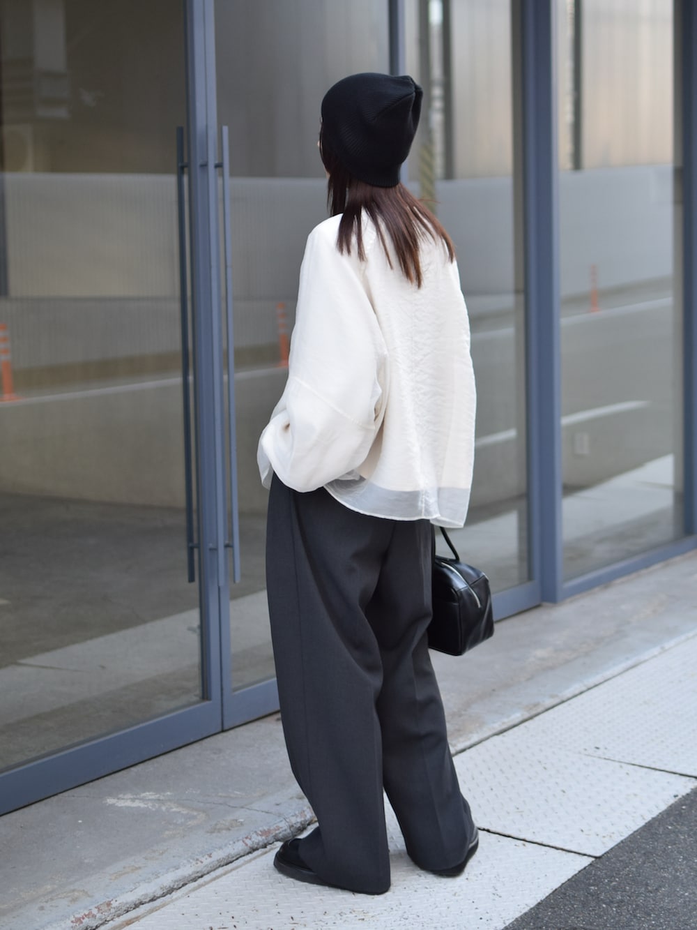 ホワイト系のTシャツ/カットソー、グレー系のその他パンツ、ブラック系のボストンバッグを着用したレディースの冬コーディネートの4枚目の写真