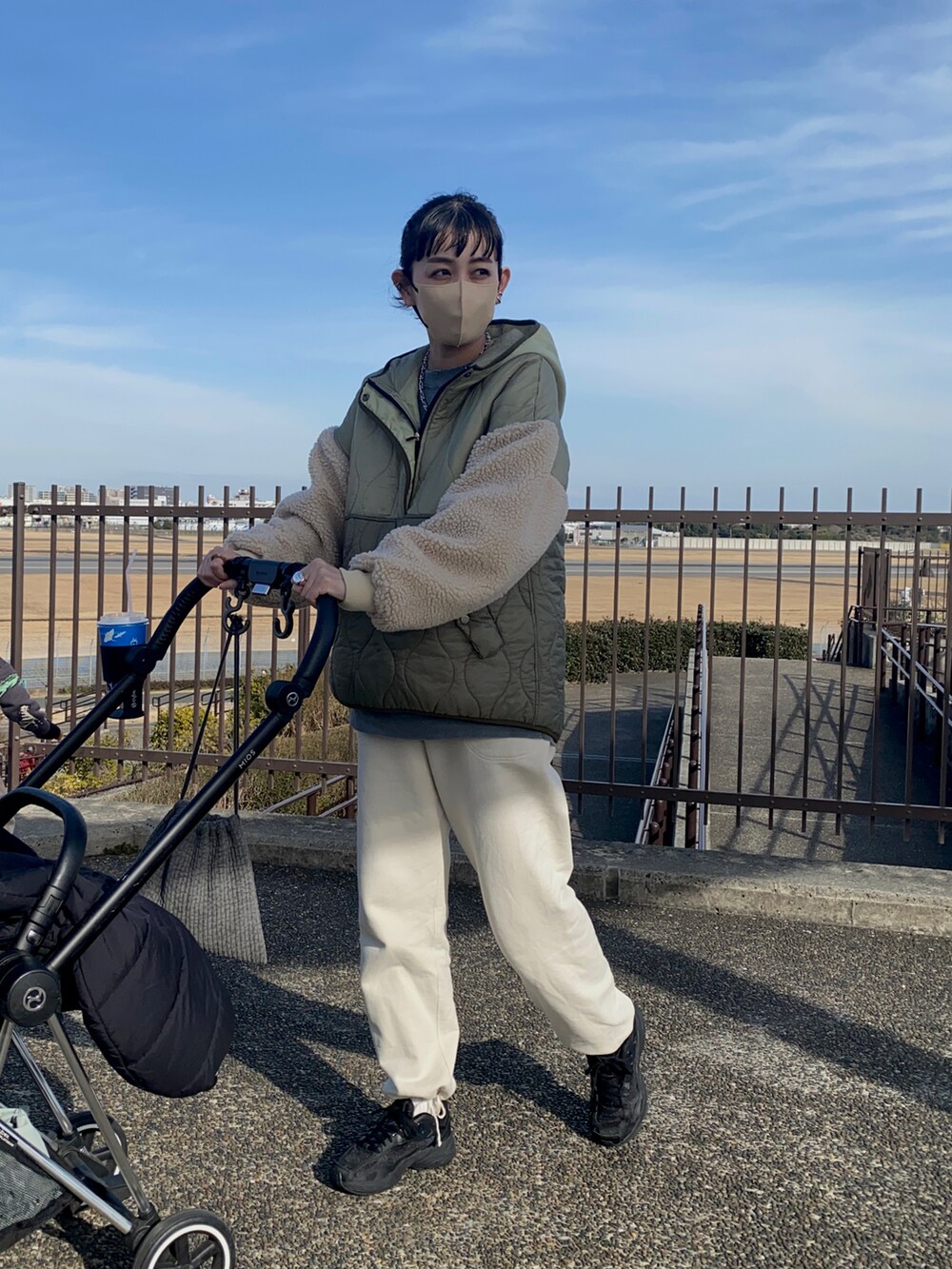 グリーン系のダウンジャケット/コート、ホワイト系のスウェットパンツ、ブラック系のスニーカーを着用したレディースの冬コーディネートの2枚目の写真