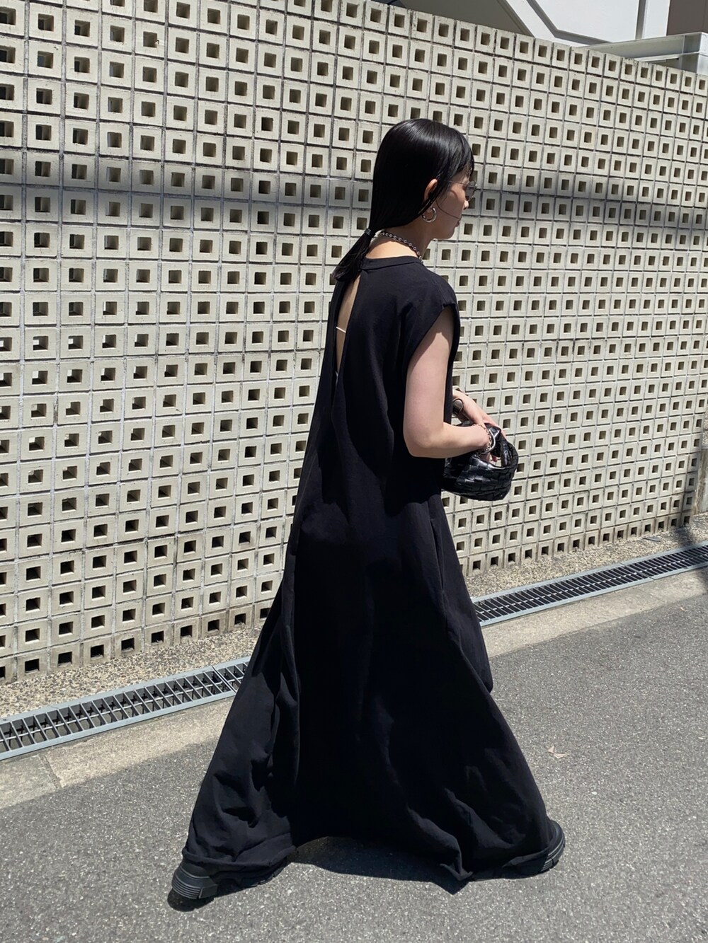 ブラック系のワンピース、シルバー系のネックレス、シルバー系のサングラスを着用したレディースの夏コーディネートの2枚目の写真