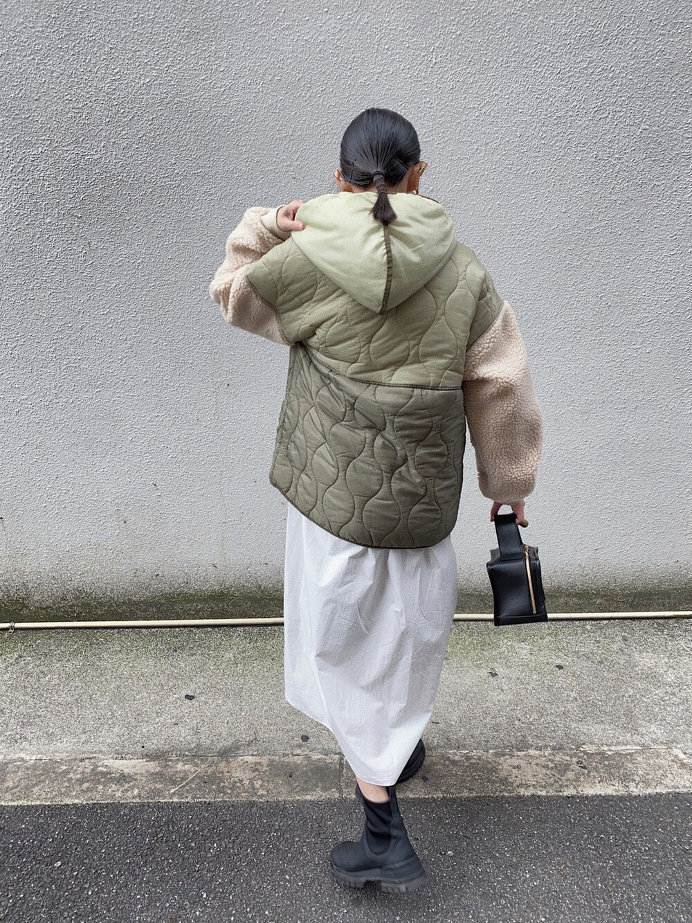 ホワイト系のシャツワンピース、ブラック系のブーツ、グリーン系のダウンジャケット/コートを着用したレディースの秋コーディネートの4枚目の写真