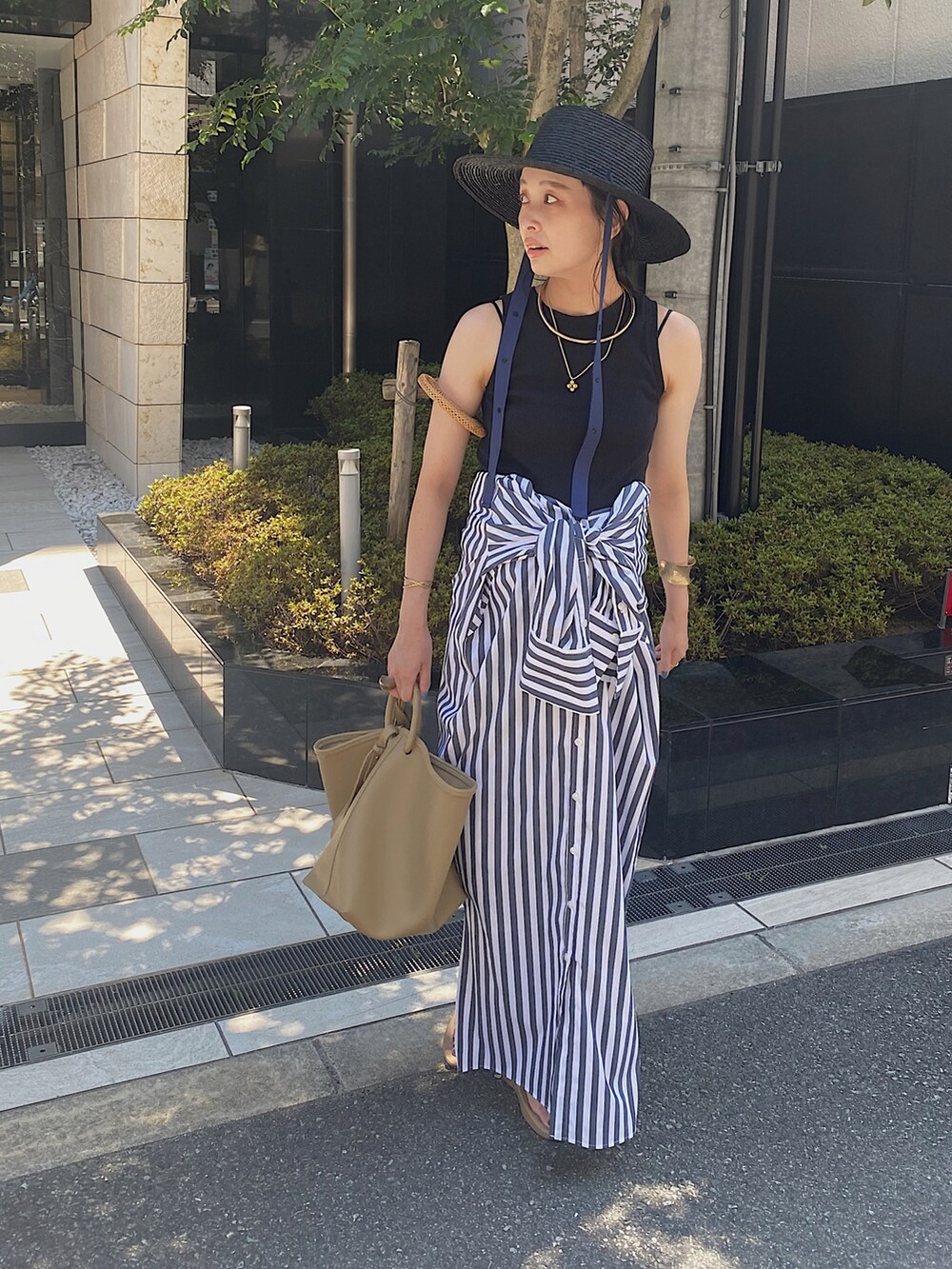 ブラック系のTシャツ/カットソー、その他のシャツワンピース、ベージュ系のハンドバッグを着用したレディースの夏コーディネートの2枚目の写真