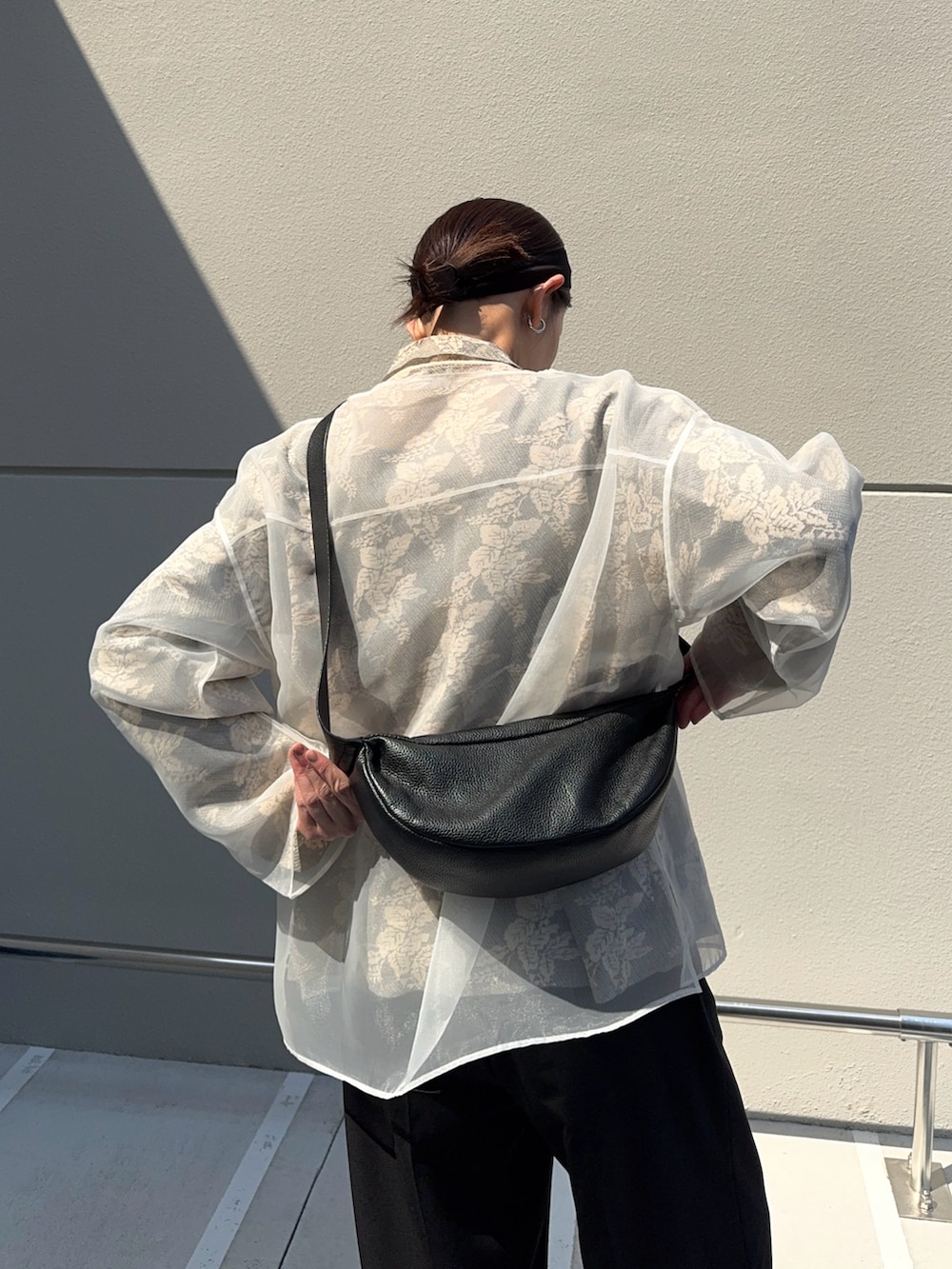 ホワイト系のシャツ/ブラウス、ブラック系のスラックス、ブラック系のローファーを着用したレディースの春コーディネートの3枚目の写真