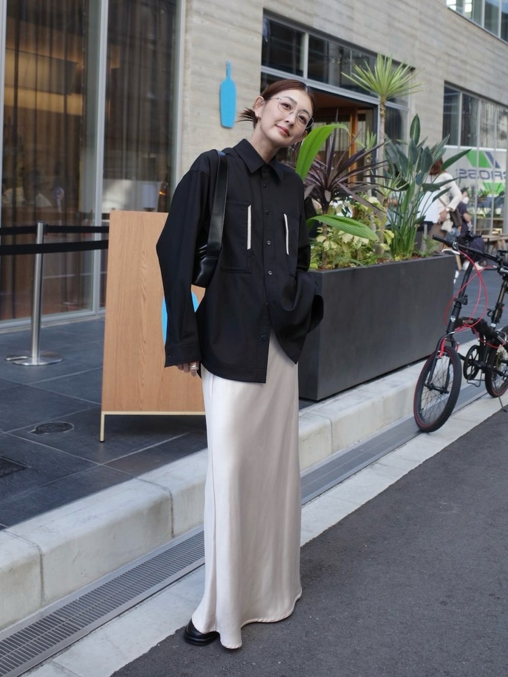 ブラック系のシャツ/ブラウス、ブラック系のスリッポン、ブラック系のショルダーバッグを着用したレディースの秋コーディネートの2枚目の写真