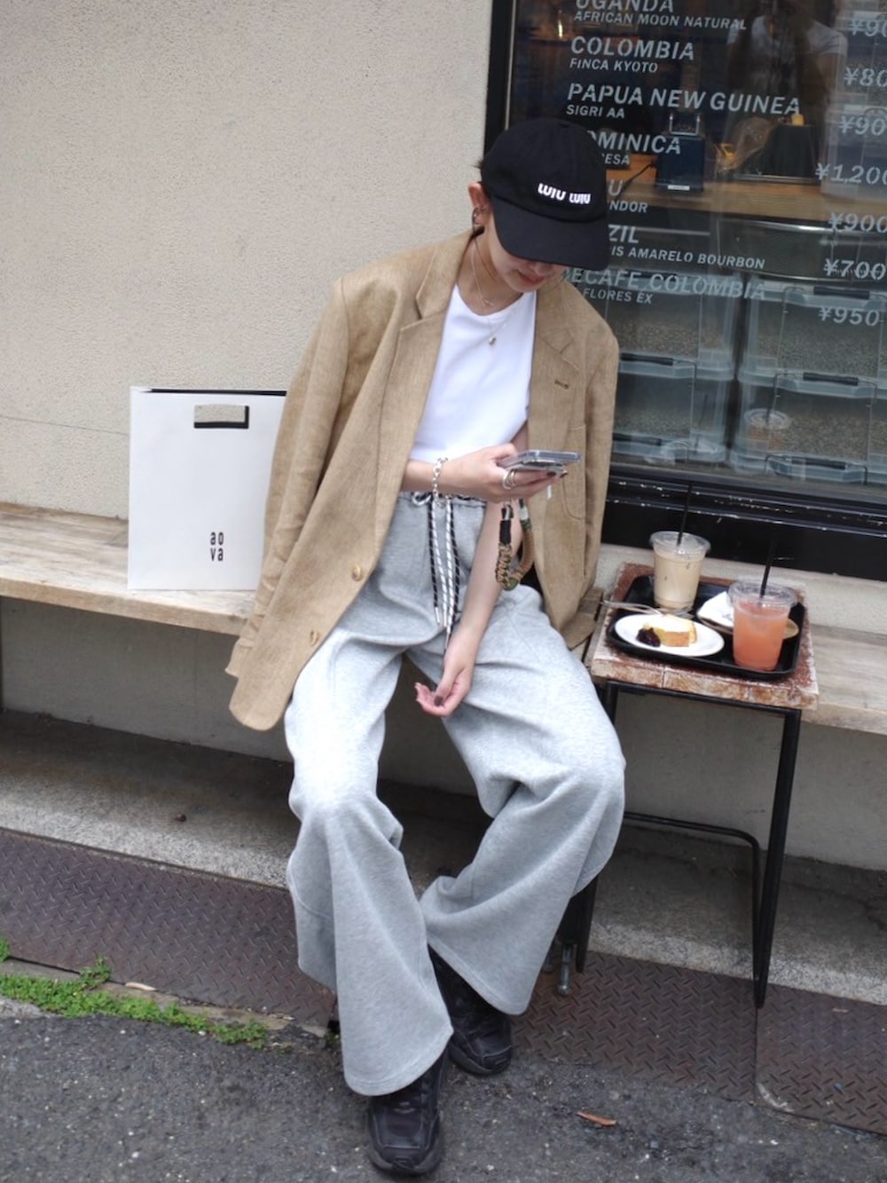 グレー系のスウェットパンツ、ブラック系のスニーカー、ベージュ系のテーラードジャケットを着用したレディースの春コーディネートの3枚目の写真