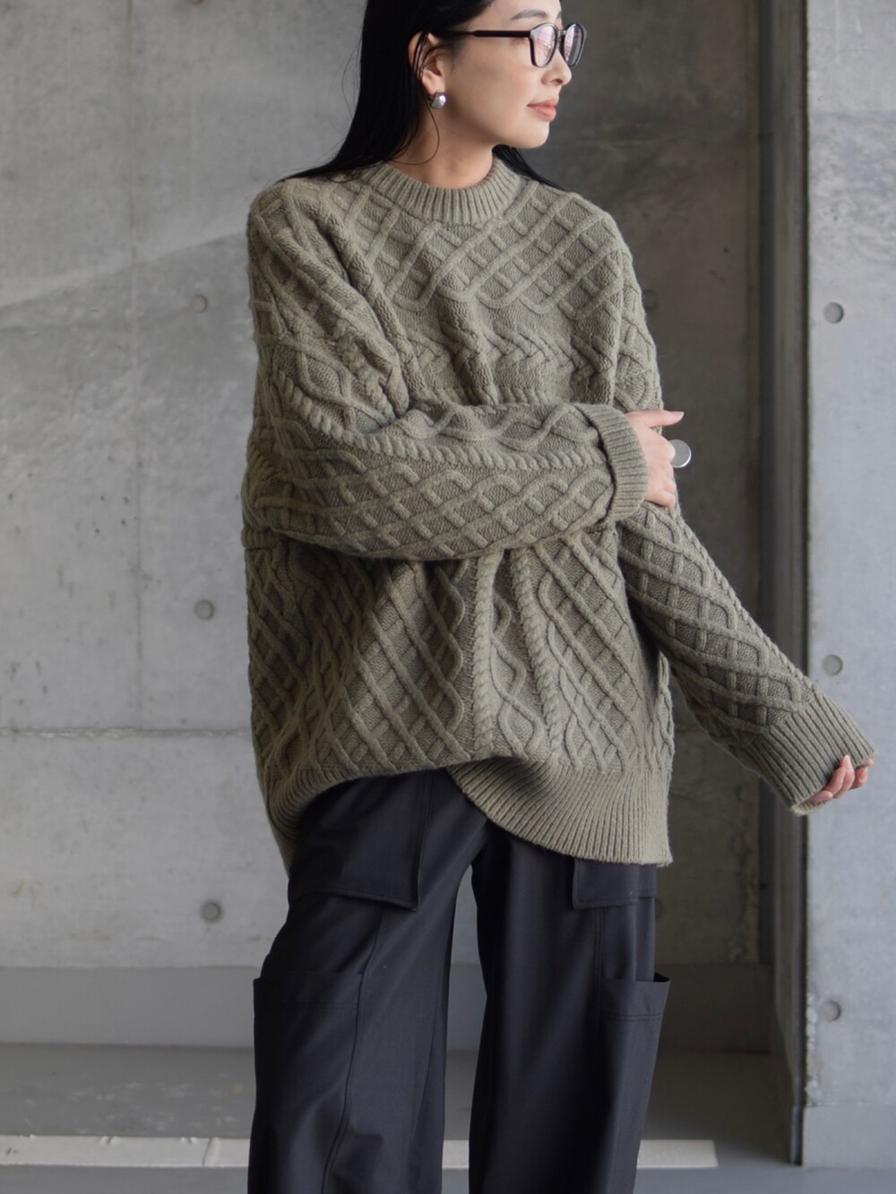 グリーン系のニット/セーター、グリーン系のカーゴパンツ、ブラック系のブーツを着用したレディースの秋コーディネートの3枚目の写真