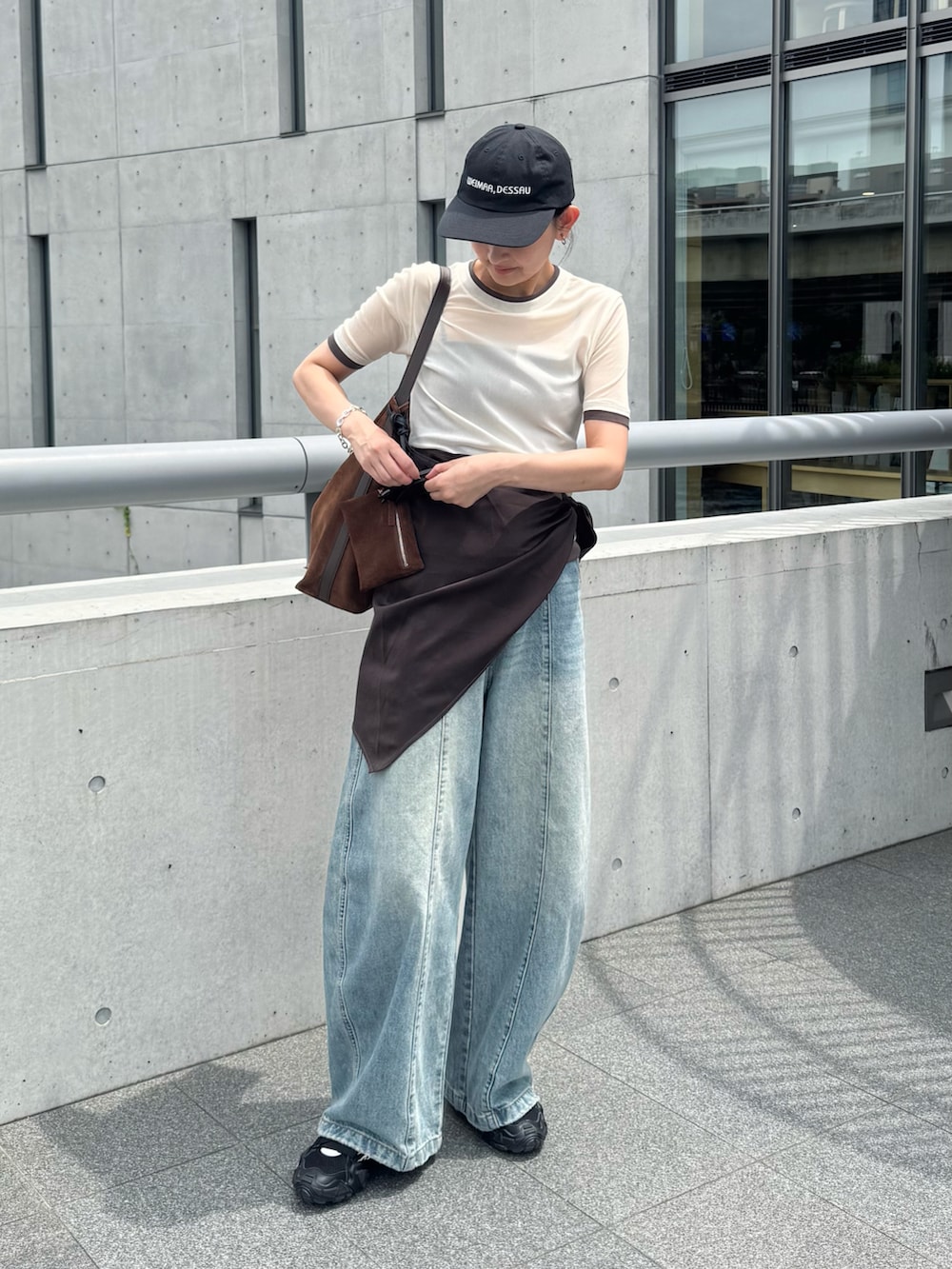 ホワイト系のTシャツ/カットソー、ブルー系のデニムパンツ、ブラウン系のショルダーバッグを着用したレディースの夏コーディネートの2枚目の写真