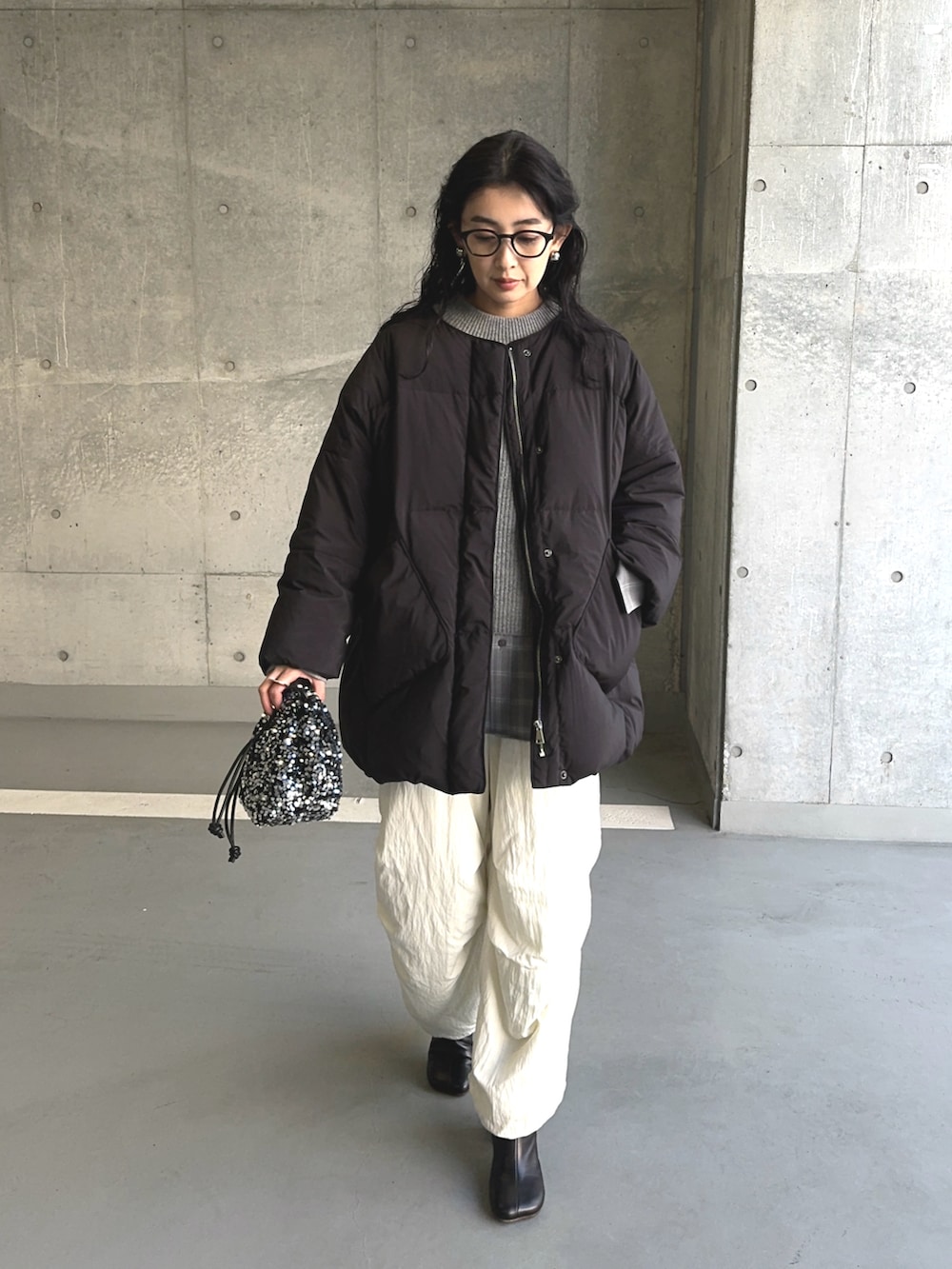 ブラック系のダウンジャケット/コート、シルバー系のショルダーバッグ、ホワイト系のその他パンツを着用したレディースの冬コーディネートの2枚目の写真