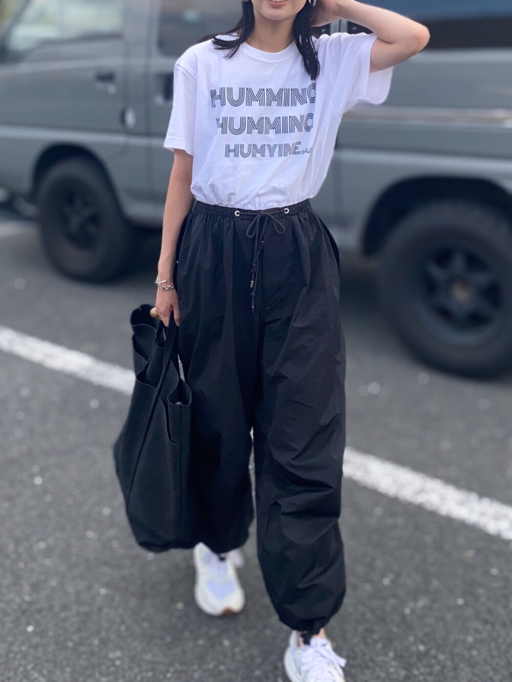 ホワイト系のTシャツ/カットソー、ブラック系のその他パンツ、ブラック系のトートバッグを着用したレディースの夏コーディネートの2枚目の写真