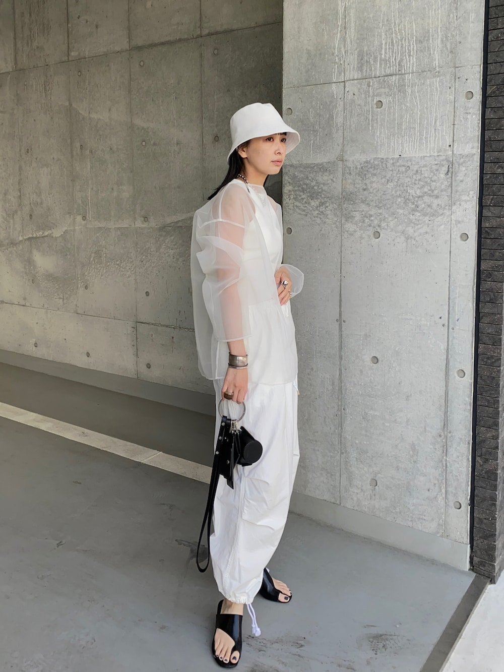 ホワイト系のその他パンツ、ブラック系のショルダーバッグ、ホワイト系のシャツ/ブラウスを着用したレディースの夏コーディネートの3枚目の写真