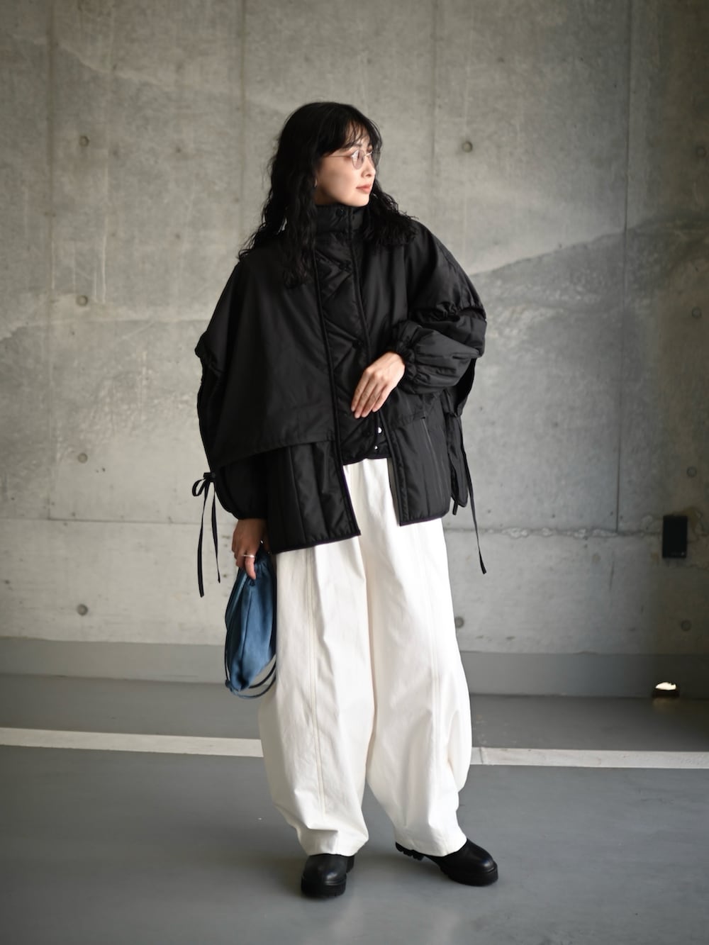 ブラック系のダウンジャケット/コート、ホワイト系のその他パンツ、ブラック系のブーツを着用したレディースの秋コーディネートの3枚目の写真