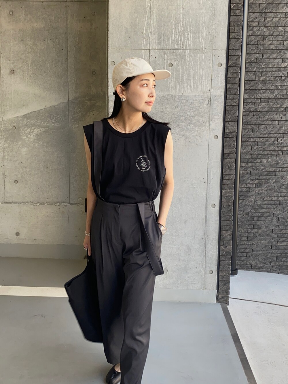 ブラック系のトートバッグ、ブラック系のバレエシューズ、ブラック系のTシャツ/カットソーを着用したレディースの夏コーディネートの3枚目の写真