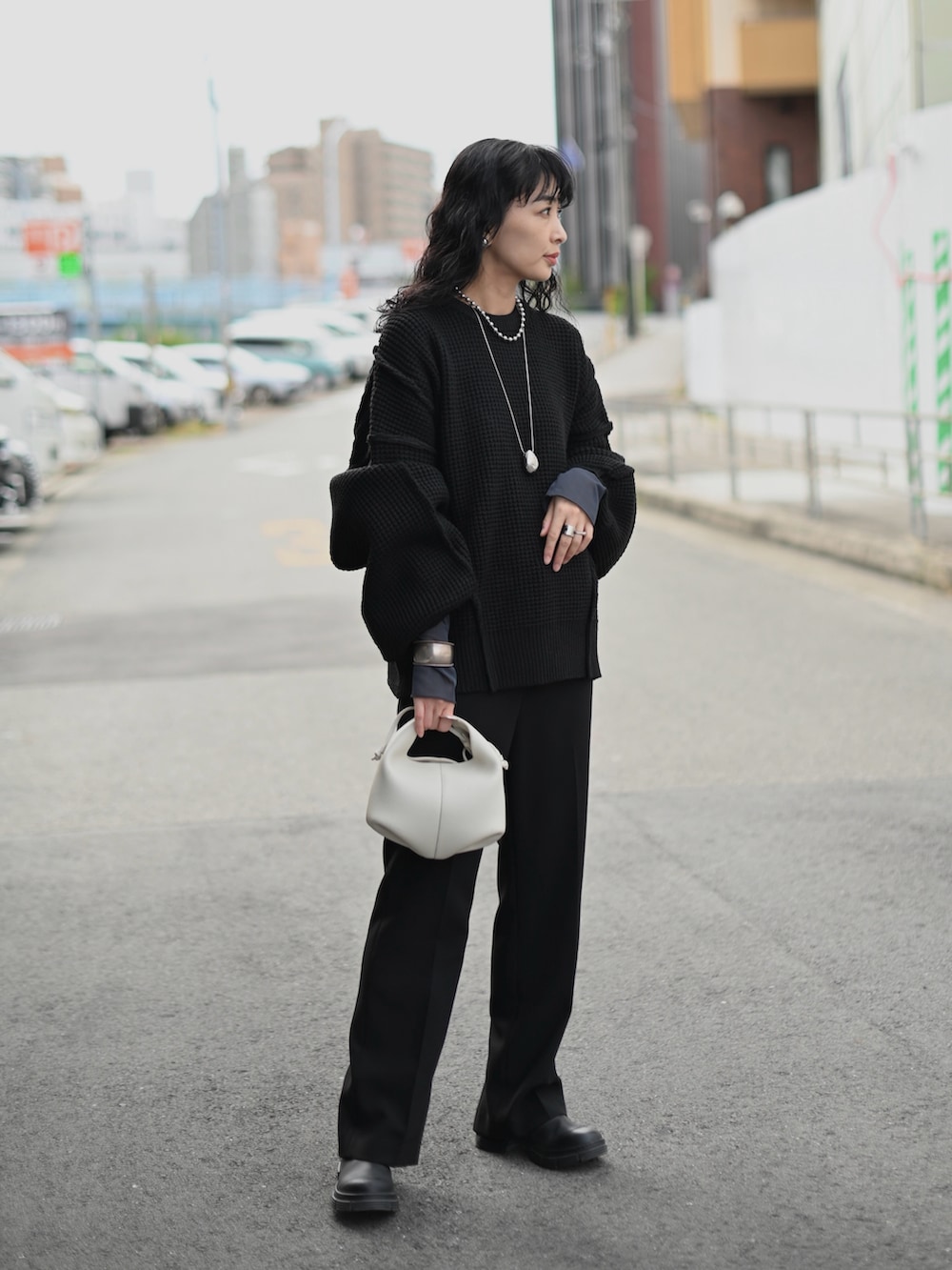 ブラック系のニット/セーター、グレー系のTシャツ/カットソー、ブラック系のブーツを着用したレディースの秋コーディネートの2枚目の写真