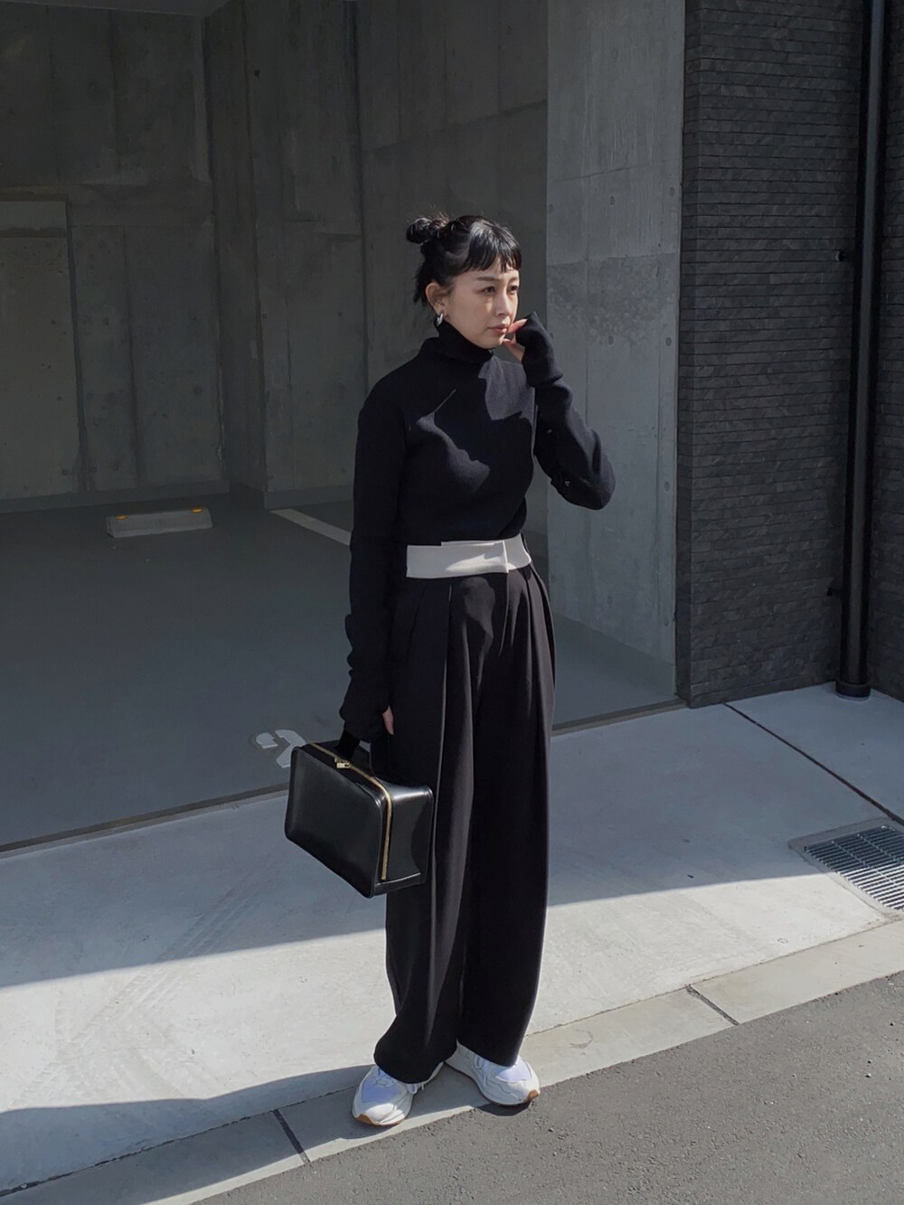 ブラック系のニット/セーター、ブラック系のパンツ、ホワイト系のスニーカーを着用したレディースの冬コーディネートの3枚目の写真