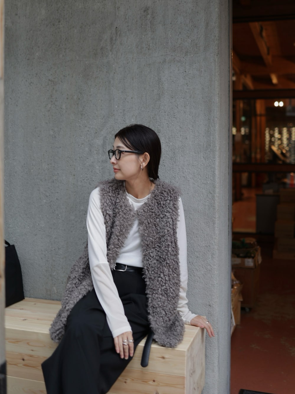 グレー系のベスト、ブラック系のスラックス、ブラック系のローファーを着用したレディースの秋コーディネートの3枚目の写真