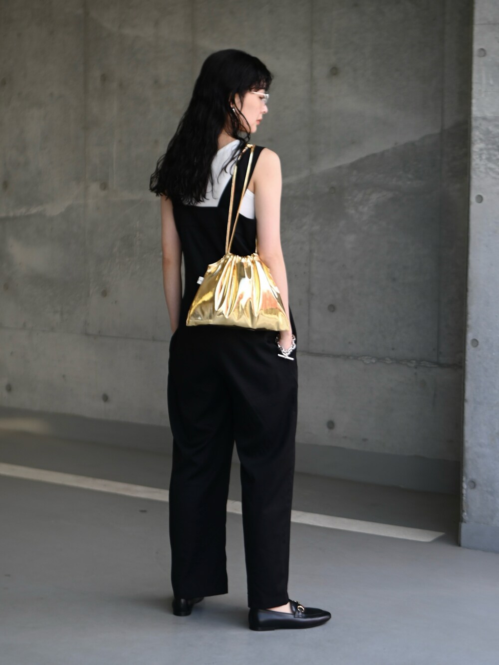ブラック系のサロペット/オーバーオール、ゴールド系のショルダーバッグ、ブラック系のローファーを着用したレディースの春コーディネートの4枚目の写真