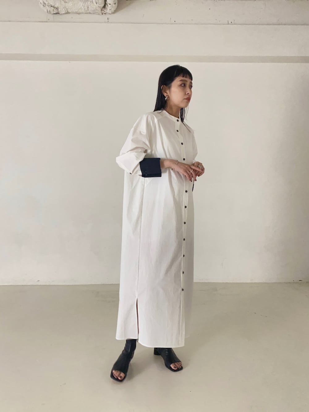 ホワイト系のシャツワンピース、ブラック系のブーツを着用したレディースの秋コーディネートの3枚目の写真