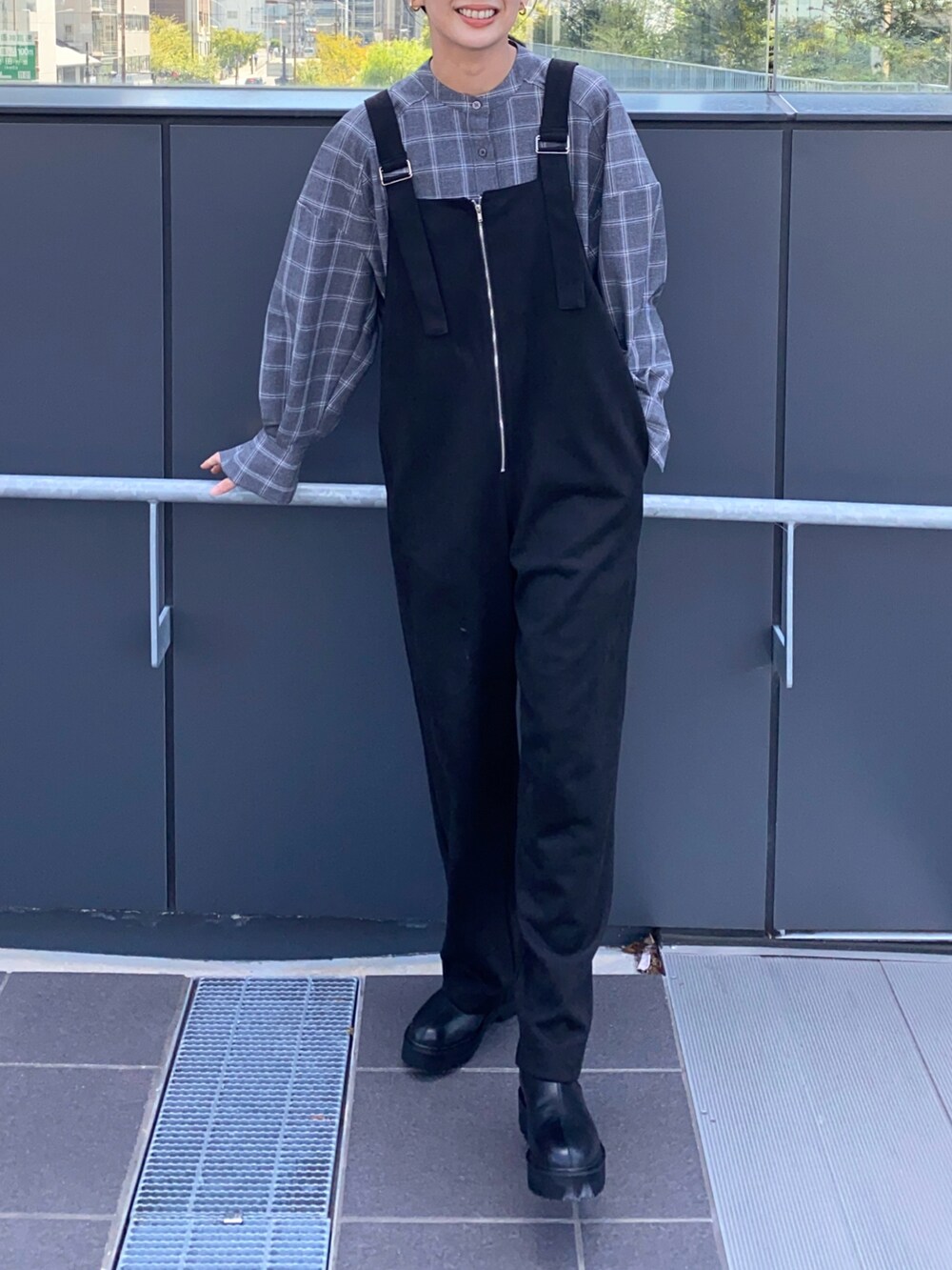 ブラック系のサロペット/オーバーオール、グレー系のシャツ/ブラウス、ブラック系のブーツを着用したレディースの冬コーディネートの2枚目の写真