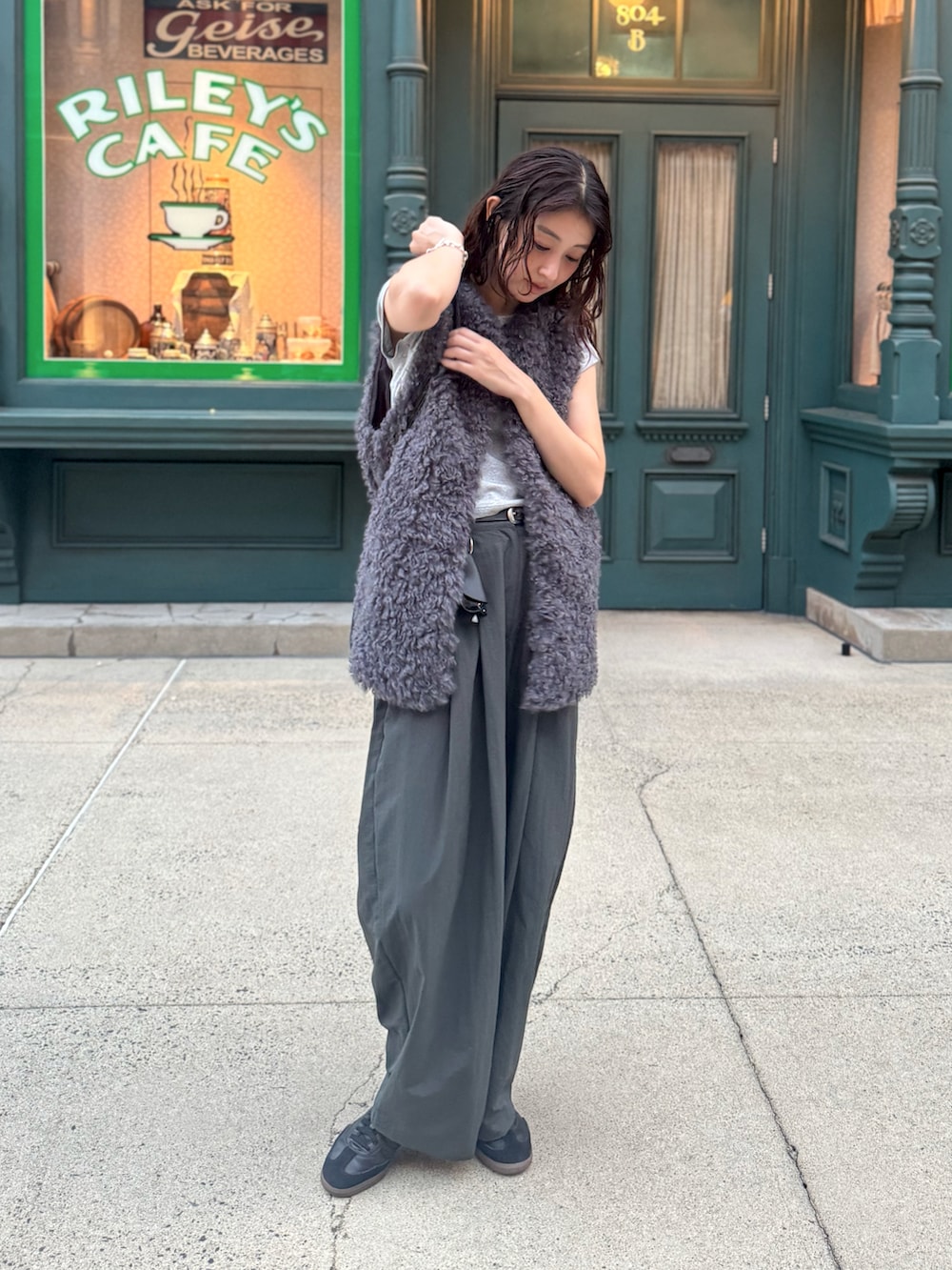 グレー系のTシャツ/カットソー、グレー系のスラックス、ブラック系のスニーカーを着用したレディースの秋コーディネートの4枚目の写真