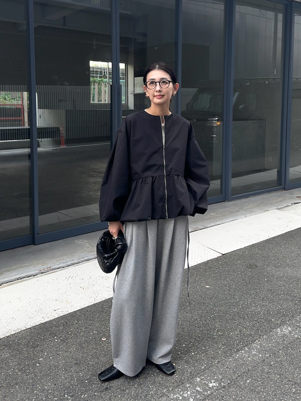 ブラック系のブルゾン、グレー系のスウェットパンツを着用したレディースの秋コーディネートの2枚目の写真