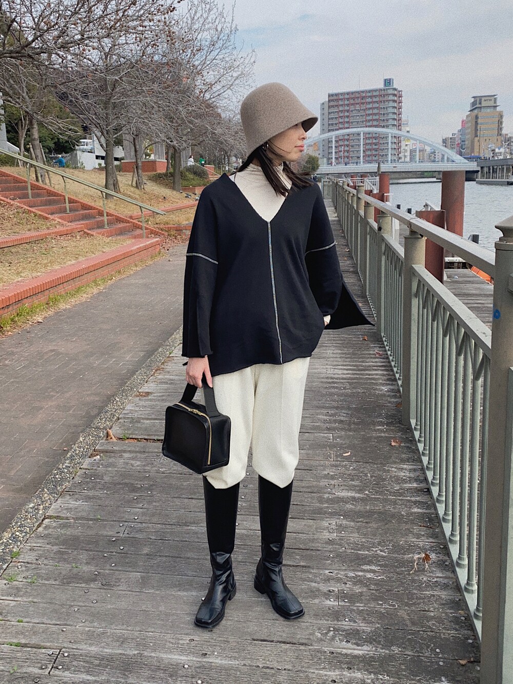 ブラック系のスウェット、ホワイト系のその他パンツ、ベージュ系の帽子を着用したレディースの冬コーディネートの2枚目の写真