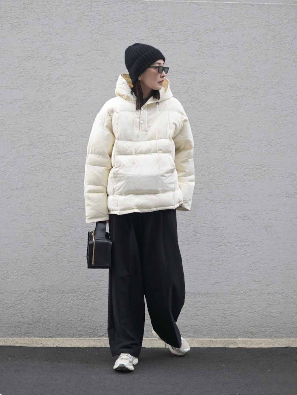 ブラック系のダウンジャケット/コート、シルバー系のスニーカー、ブラック系のサングラスを着用したレディースの冬コーディネートの3枚目の写真