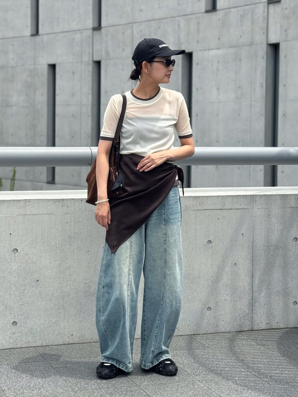 ホワイト系のTシャツ/カットソー、ブルー系のデニムパンツ、ブラウン系のショルダーバッグを着用したレディースの夏コーディネートの3枚目の写真
