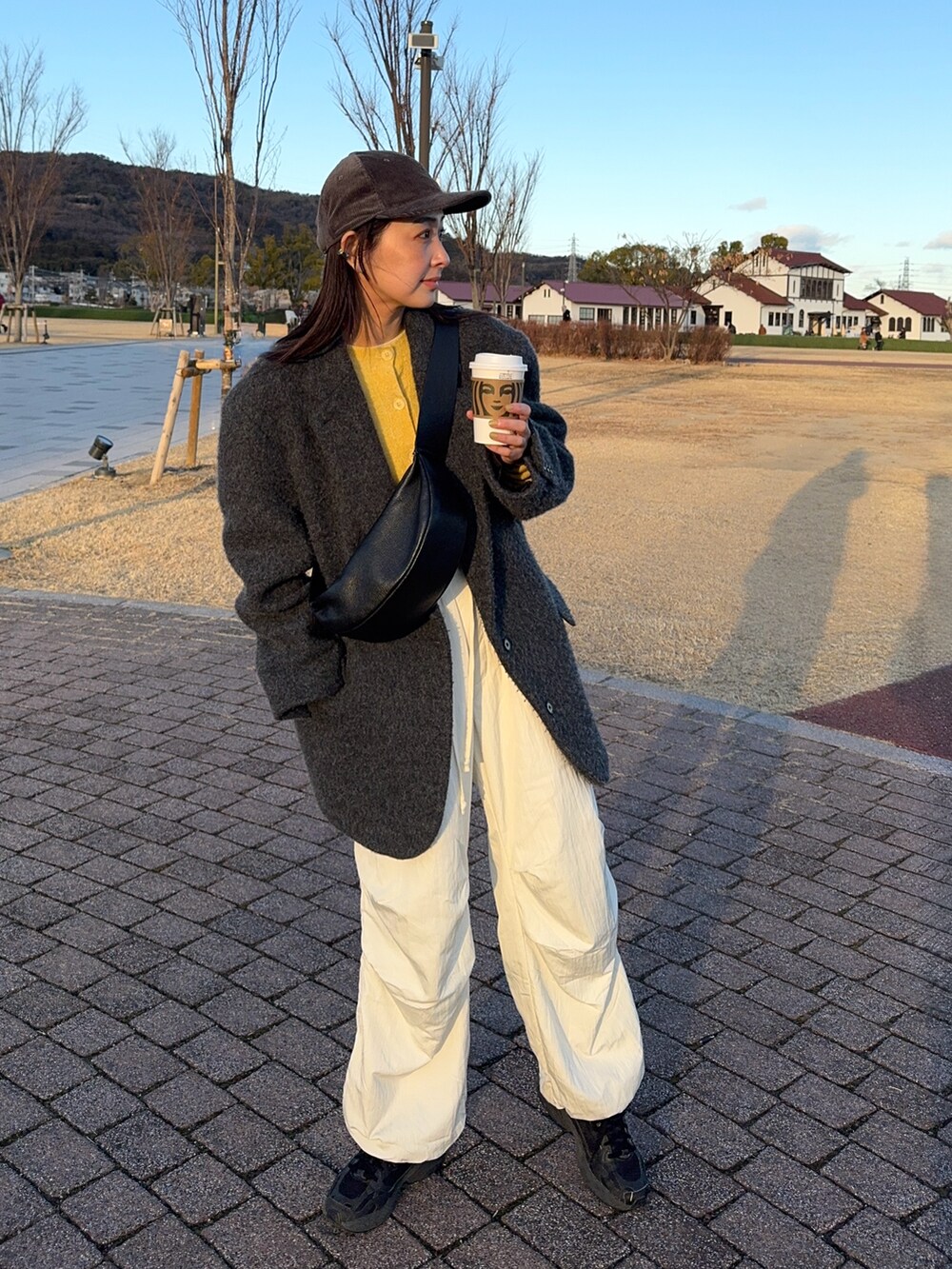 ブラック系のショルダーバッグ、イエロー系のカーディガン/ボレロ、ホワイト系のその他パンツを着用したレディースの冬コーディネートの4枚目の写真