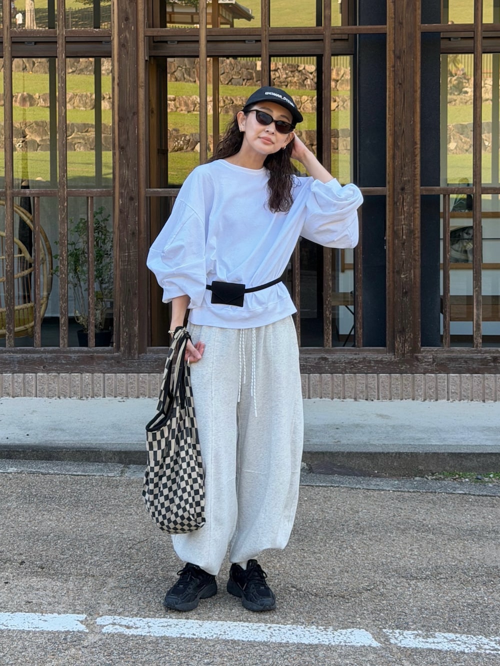 ホワイト系のTシャツ/カットソー、グレー系のスウェットパンツ、ブラック系のトートバッグを着用したレディースの秋コーディネートの5枚目の写真