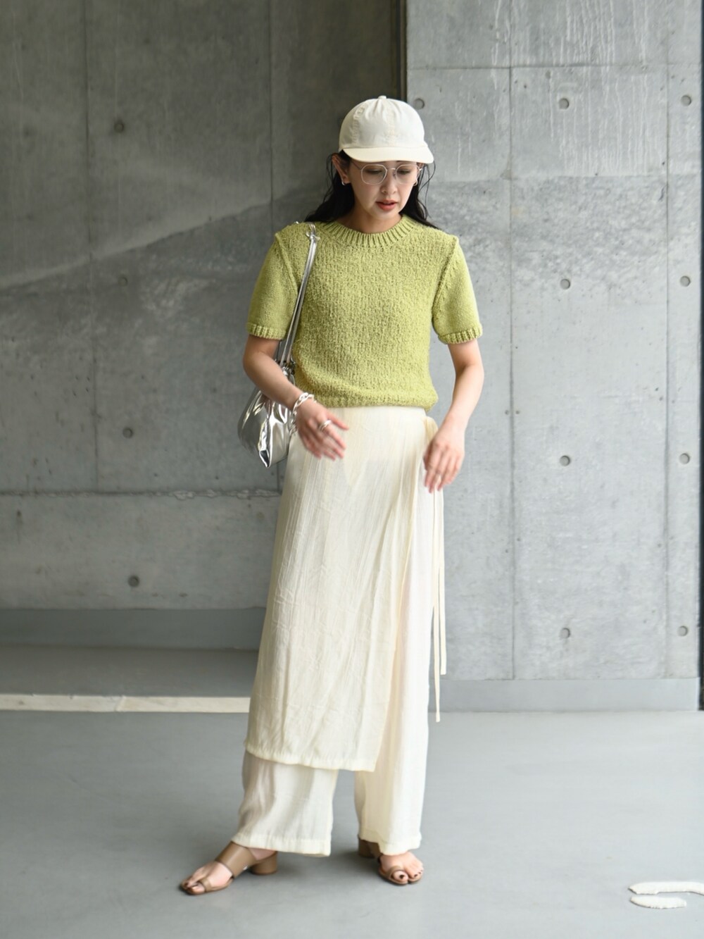 グリーン系のニット/セーター、ホワイト系のその他パンツ、ブラウン系のサンダルを着用したレディースの夏コーディネートの2枚目の写真