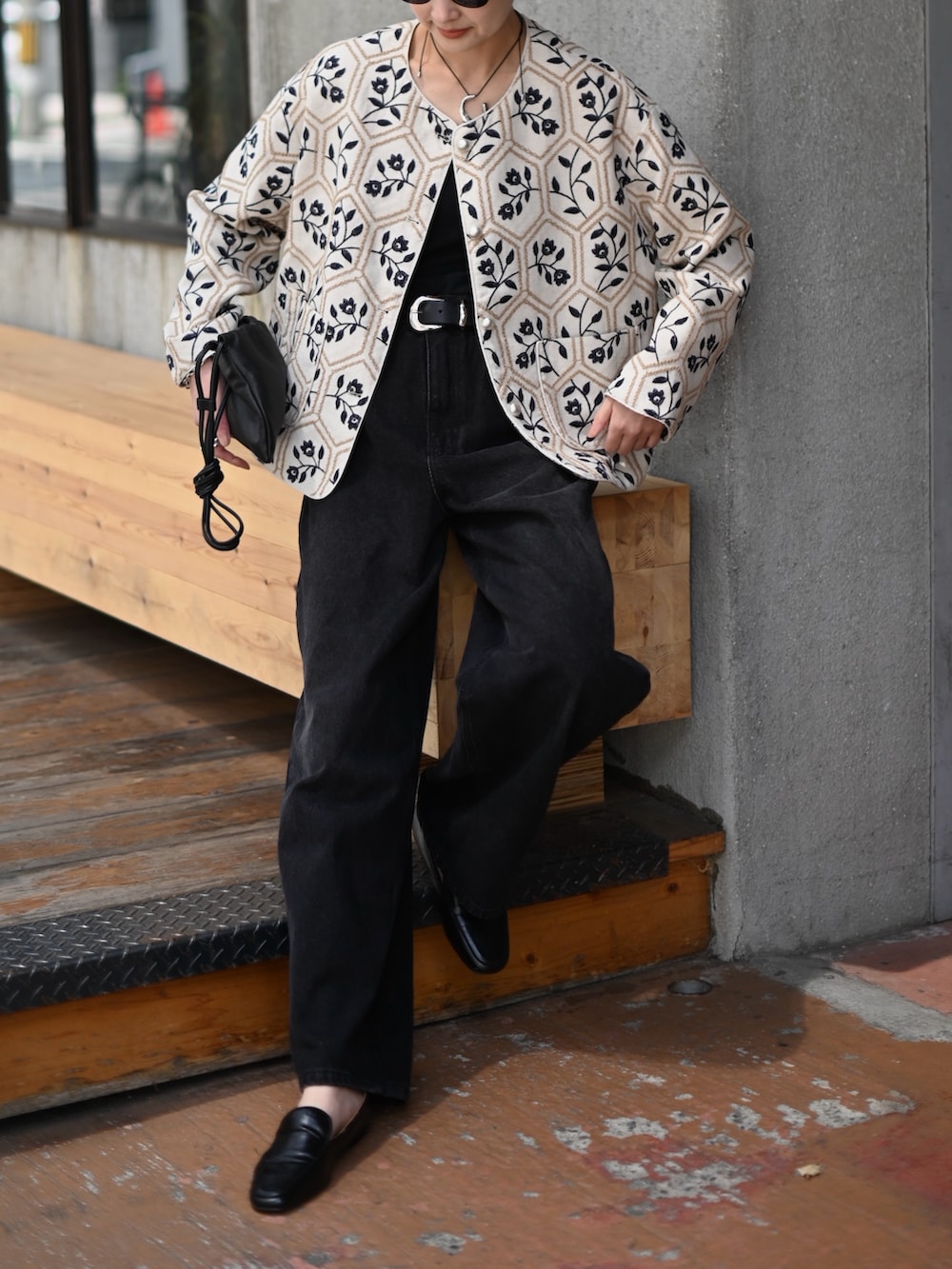 ブラック系のデニムパンツ、ブラック系のチューブトップ、ベージュ系のノーカラージャケットを着用したレディースの春コーディネートの4枚目の写真