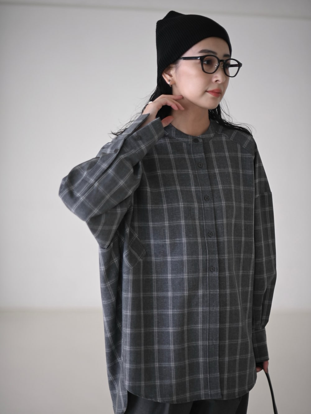 グレー系のシャツ/ブラウス、グレー系のスラックス、ブラック系のショルダーバッグを着用したレディースの秋コーディネートの4枚目の写真