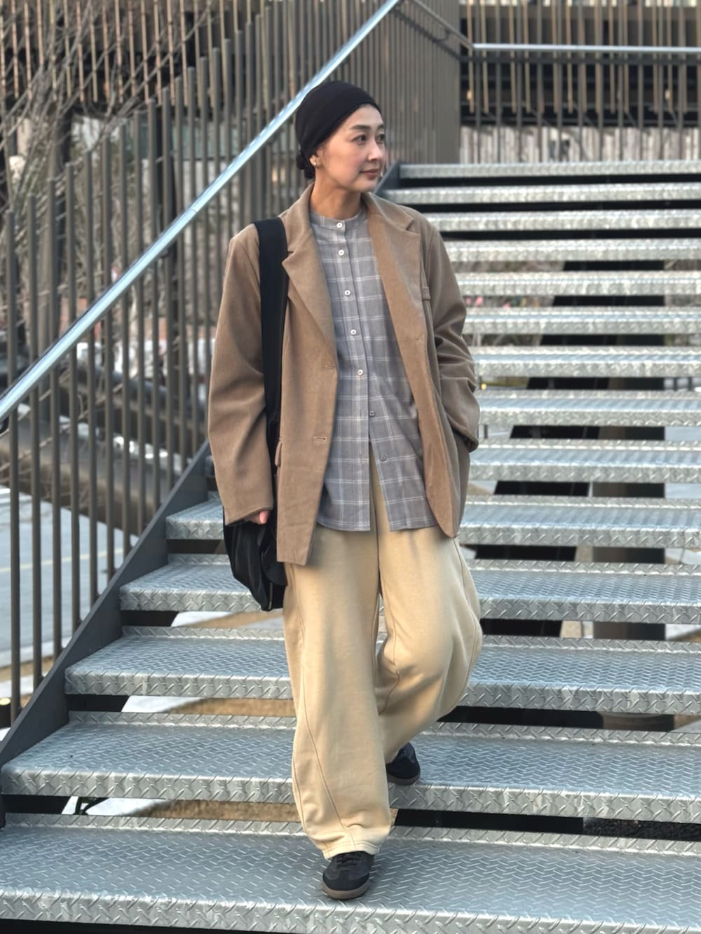 グレー系のシャツ/ブラウス、ベージュ系のスウェットパンツ、ブラック系のトートバッグを着用したレディースの春コーディネートの3枚目の写真