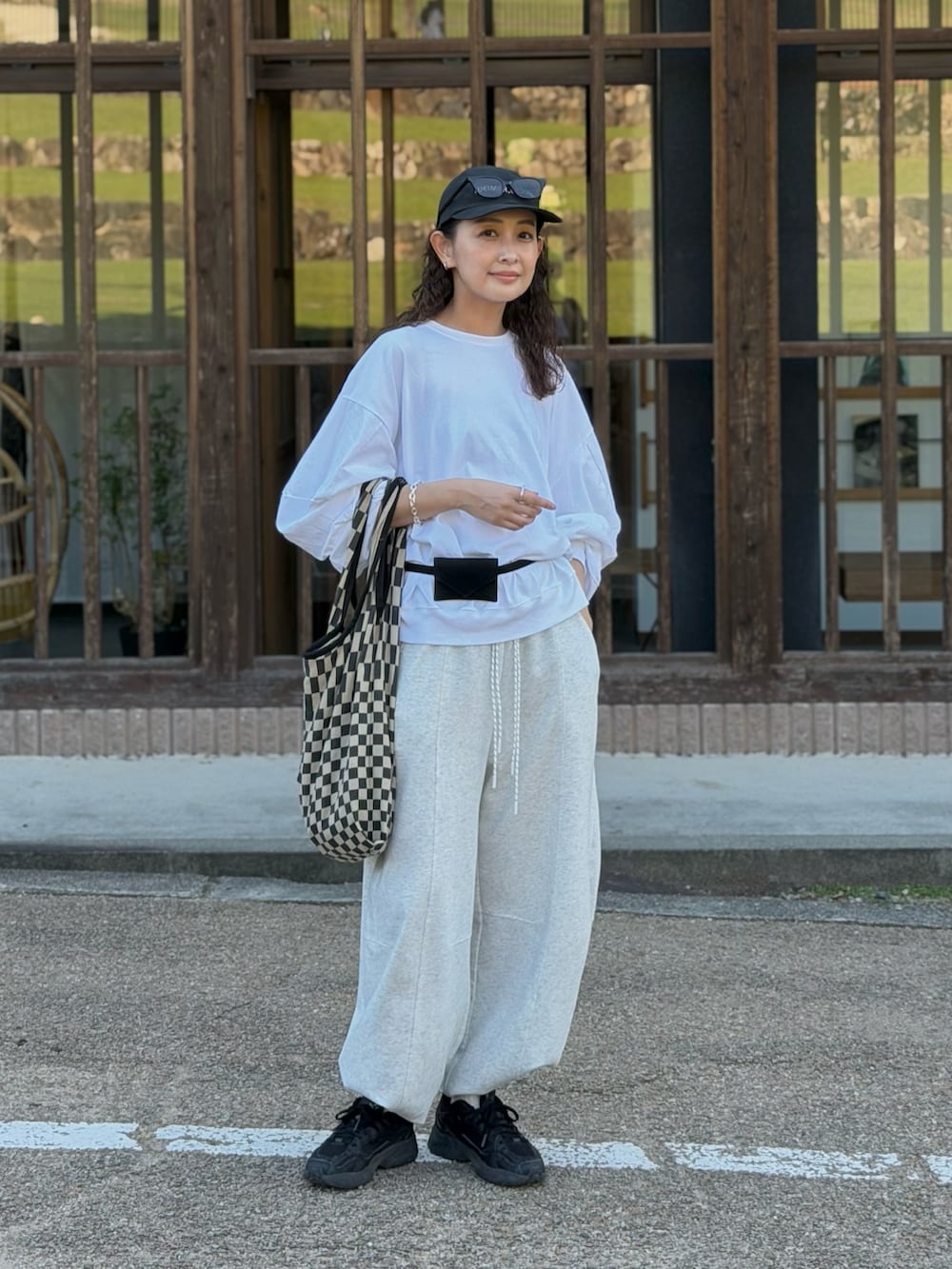 ホワイト系のTシャツ/カットソー、グレー系のスウェットパンツ、ブラック系のトートバッグを着用したレディースの秋コーディネートの4枚目の写真